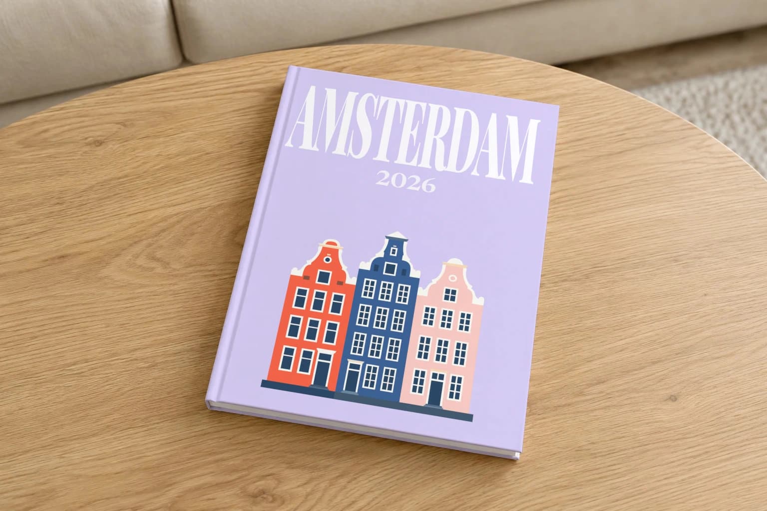 Amsterdam hardcover photo book with the illustrated cover of the canal houses, on a round oak coffee table in a bright living room
