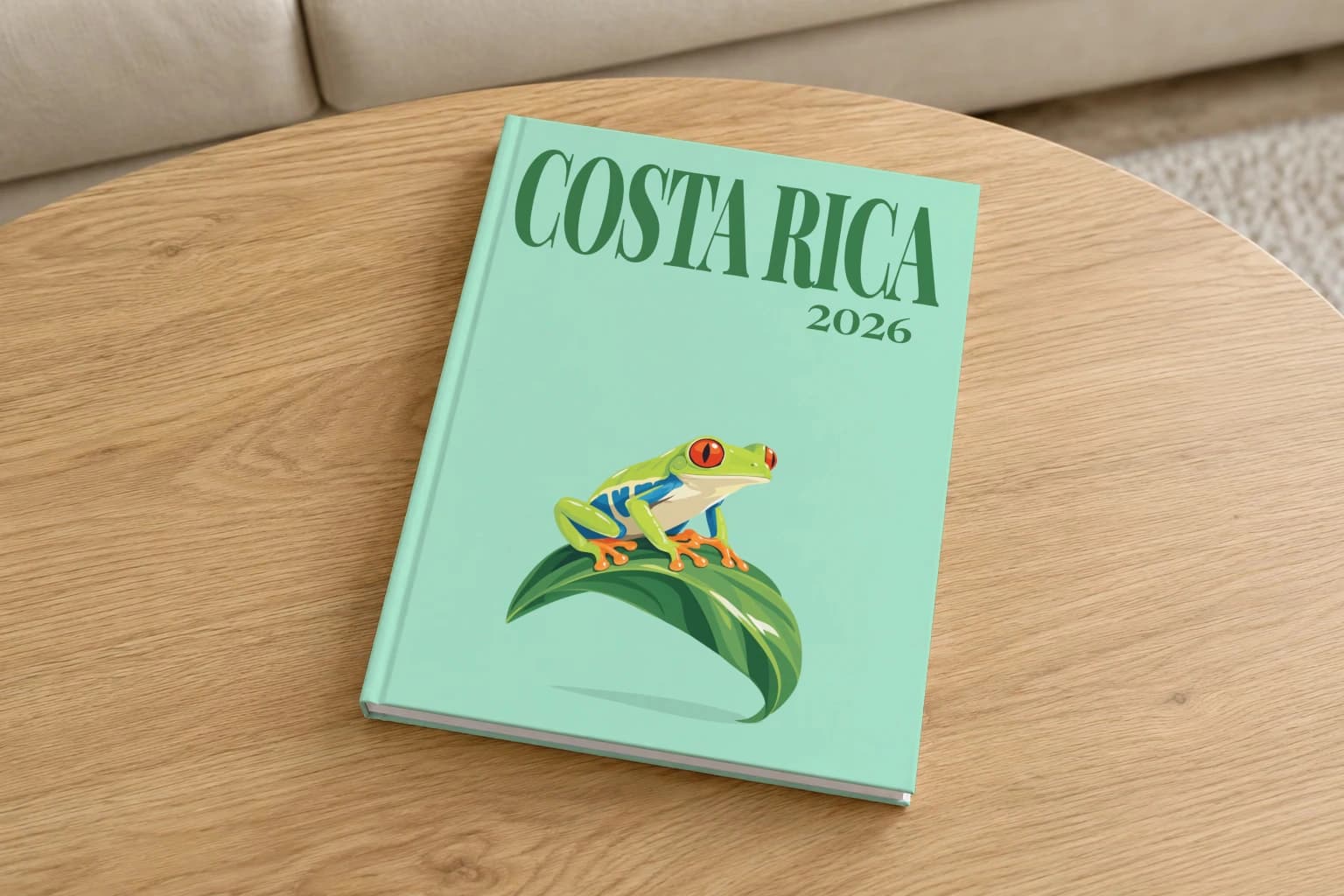 Costa Rica hardcover photo book with the illustrated cover of the red-eyed tree frog, on a round oak coffee table in a bright living room