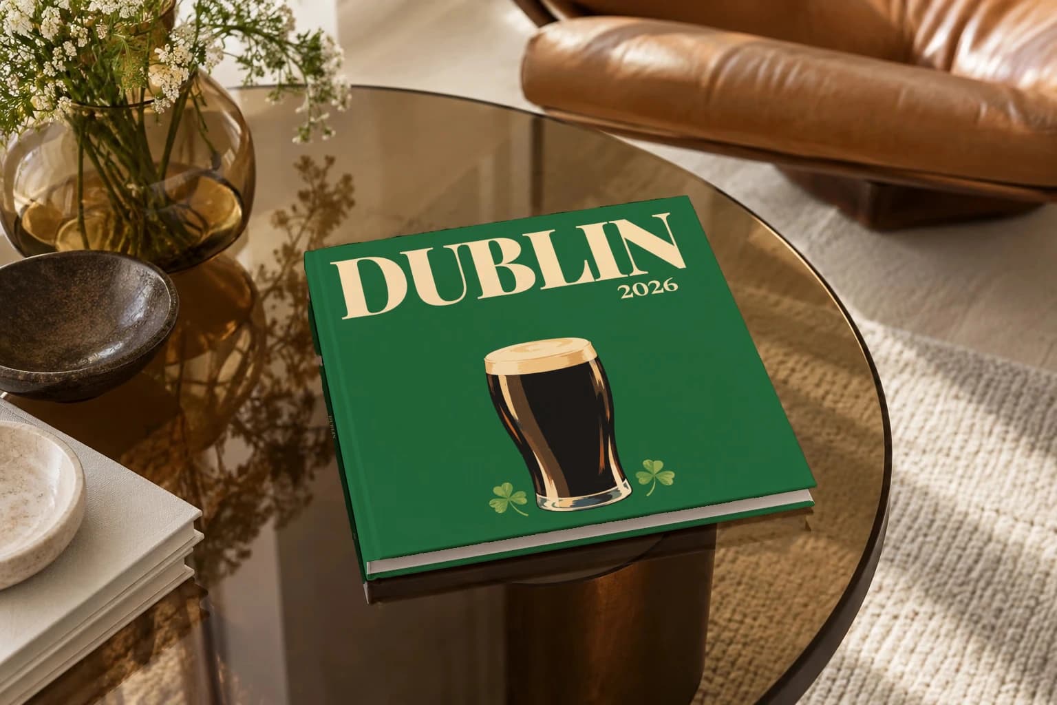 Dublin square hardcover photo book with the illustrated cover of the pint of stout, on a smoked glass coffee table beside a leather armchair in warm afternoon light