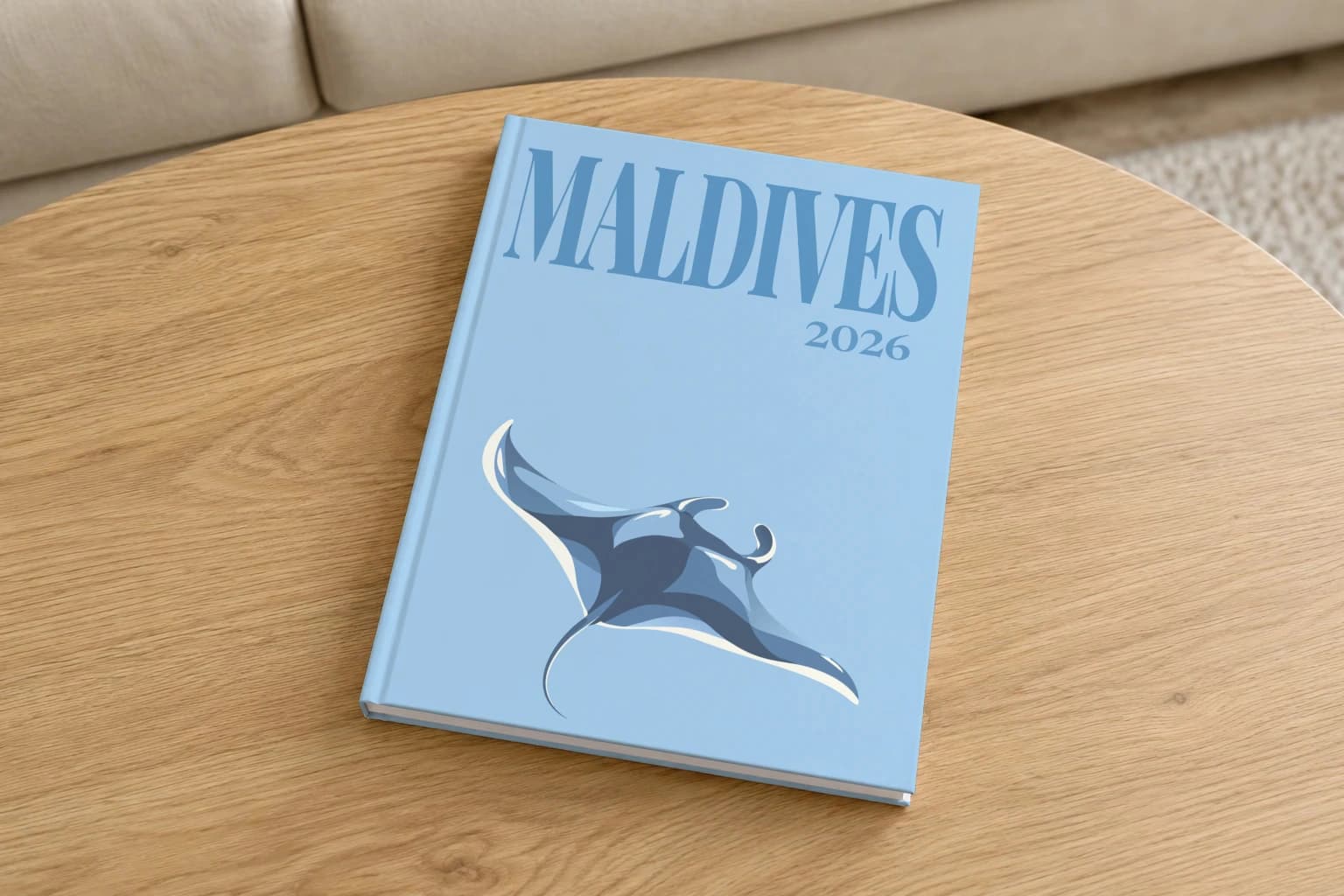 Maldives hardcover photo book with the illustrated cover of the manta ray, on a round oak coffee table in a bright living room