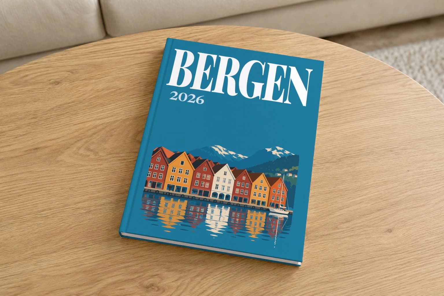 Bergen hardcover photo book with the illustrated cover of the Bryggen wharf, on a round oak coffee table in a bright living room