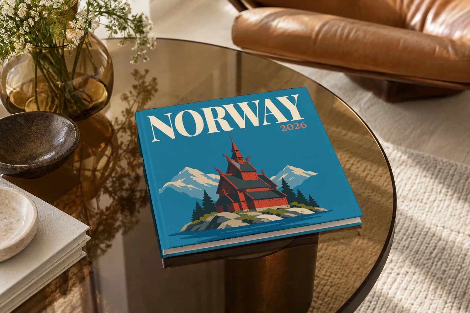 Norway square hardcover photo book with the illustrated cover of the stave church, on a smoked glass coffee table beside a leather armchair in warm afternoon light