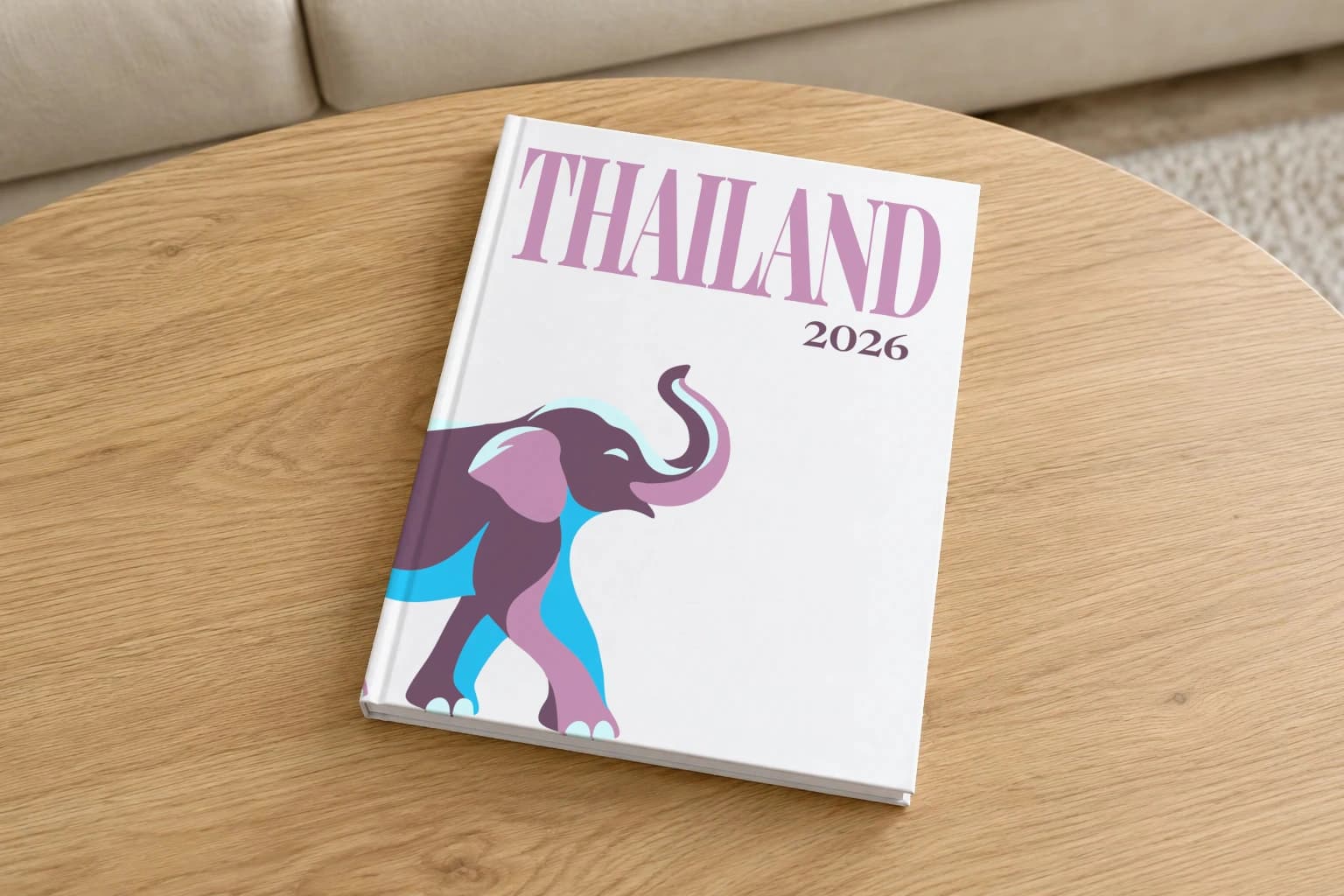 Thailand hardcover photo book with the illustrated cover of an elephant on white, on a round oak coffee table in a bright living room