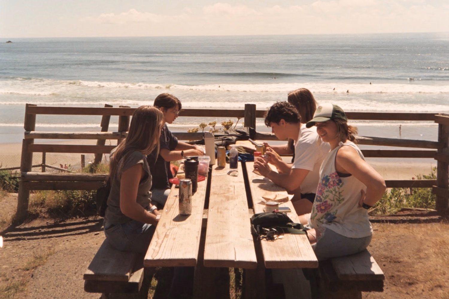Group gathered around a picnic table overlooking the beach