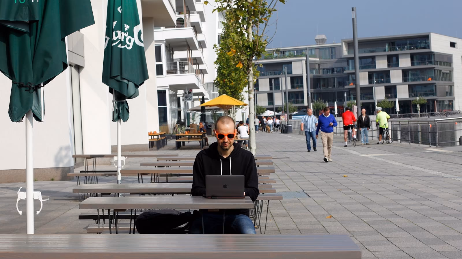 A digital nomad working on a laptop in an outdoor plaza