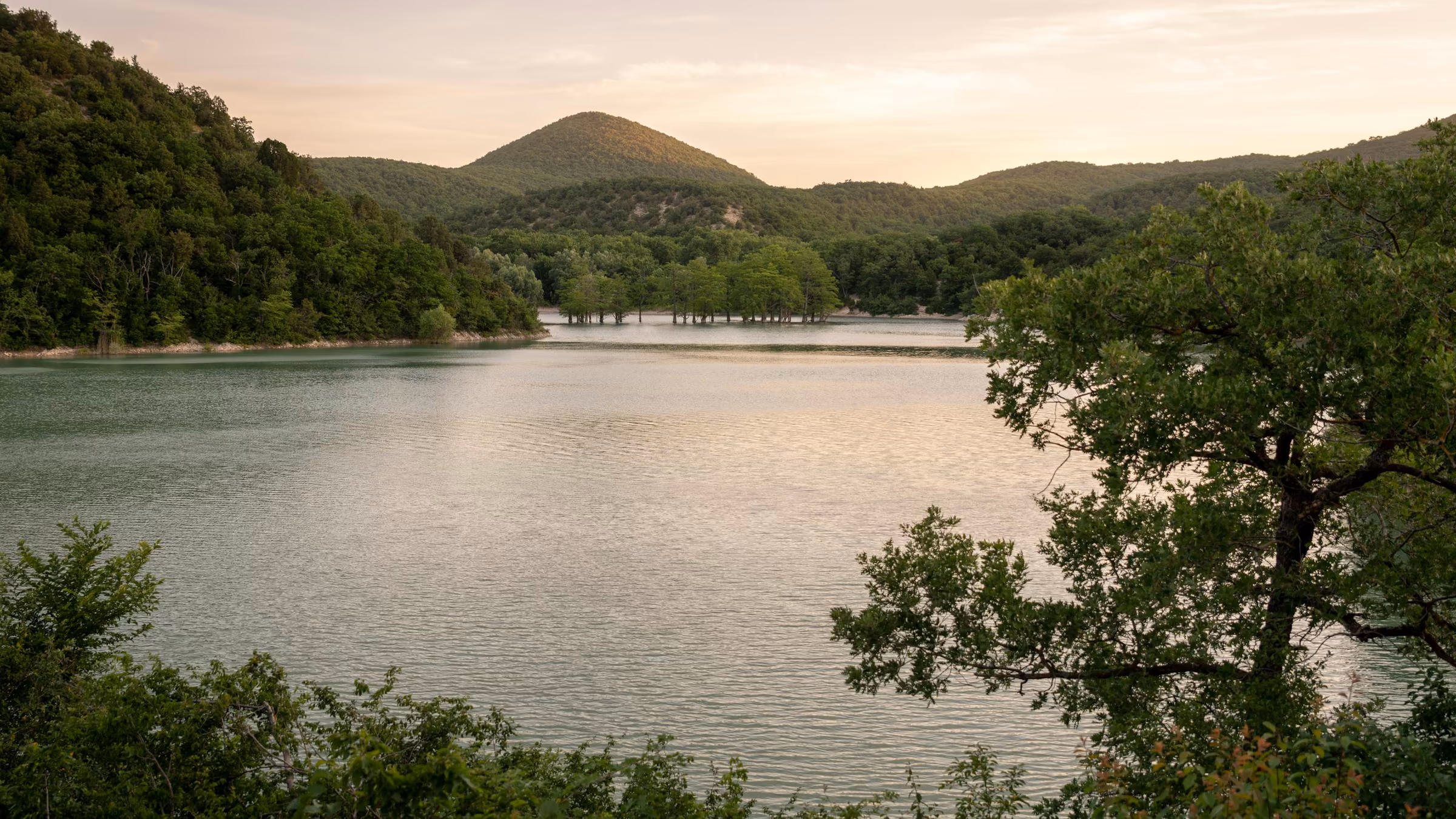 A peaceful lake surrounded by mountains and forest