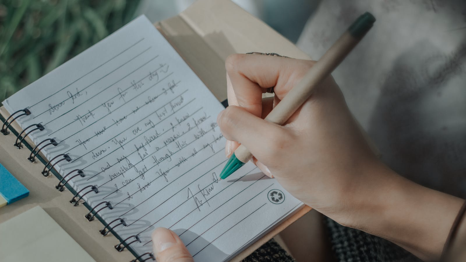 A hand writing a private entry in a notebook