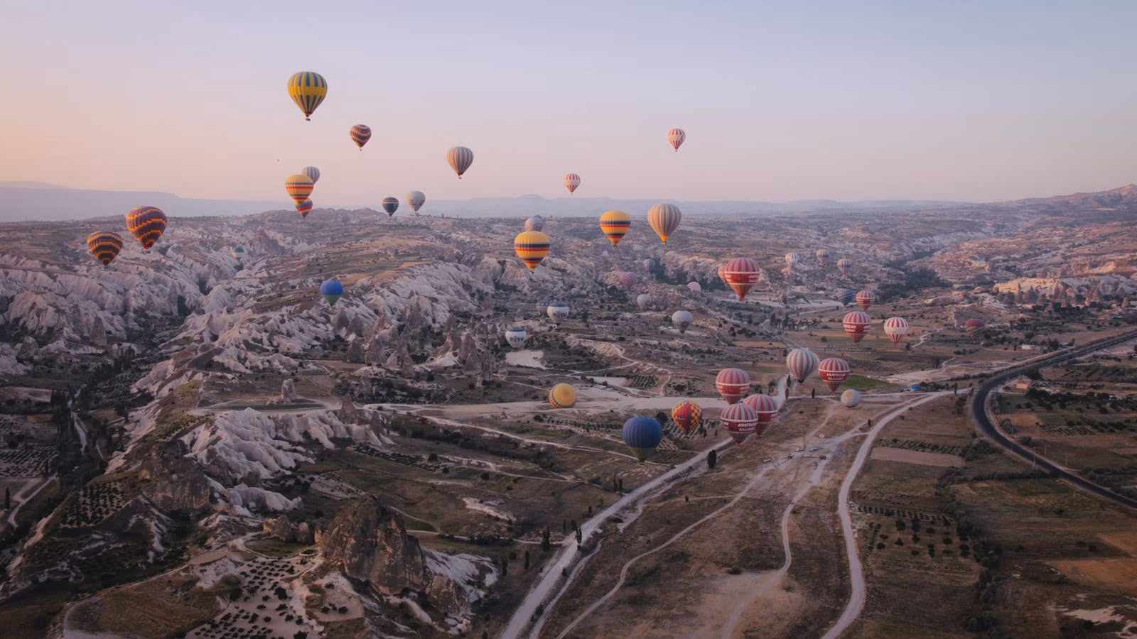 Hot-air balloons floating over Cappadocia at sunrise