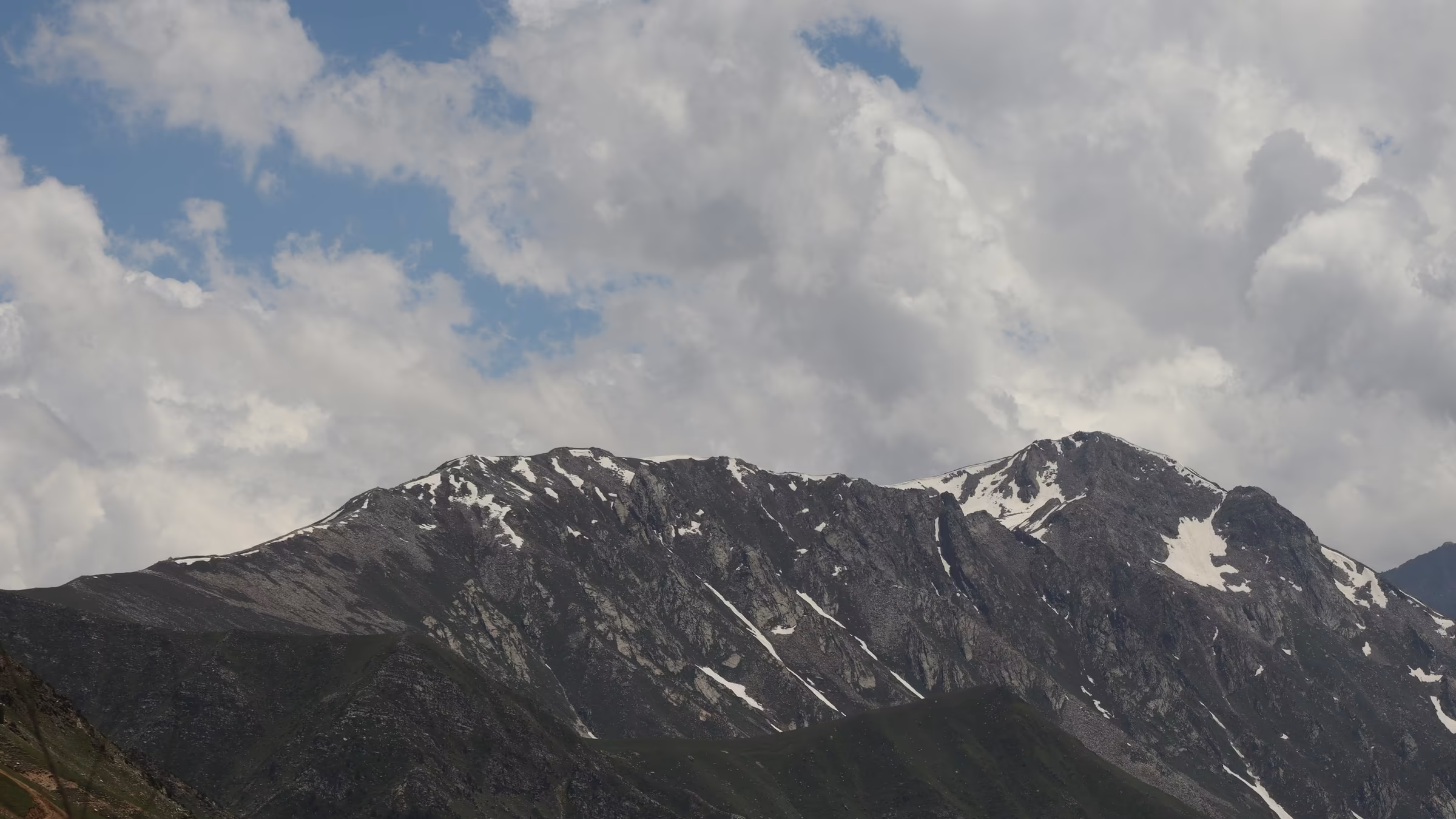 A snow-covered mountain range beneath a blue sky