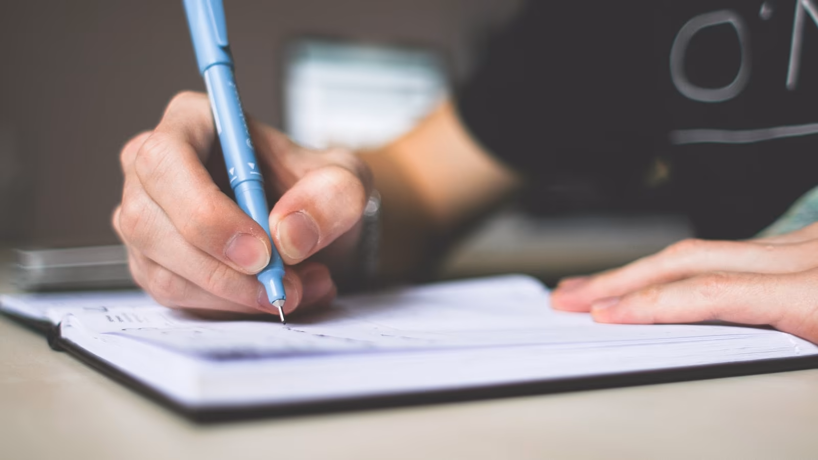 A hand writing a travel diary entry