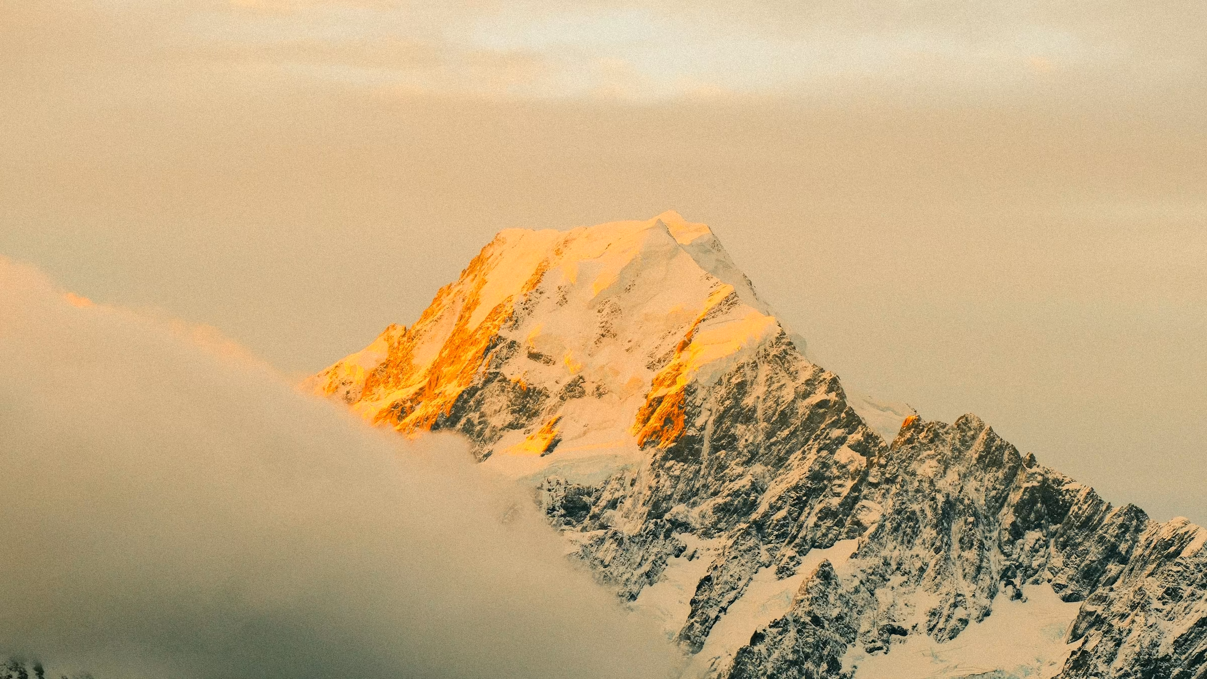 A golden mountain peak lit by low sunlight