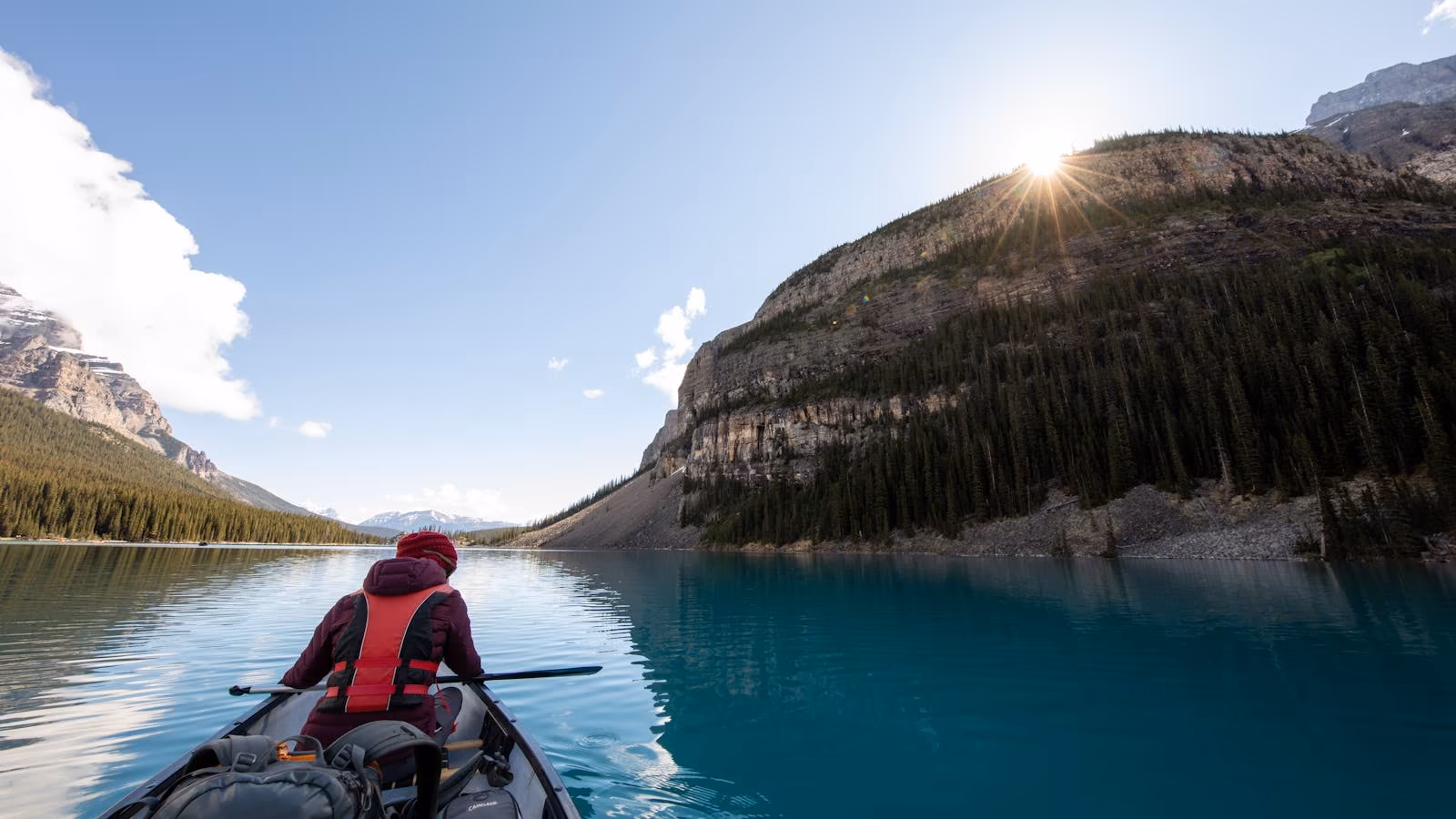 A kayaker paddling across a mountain lake