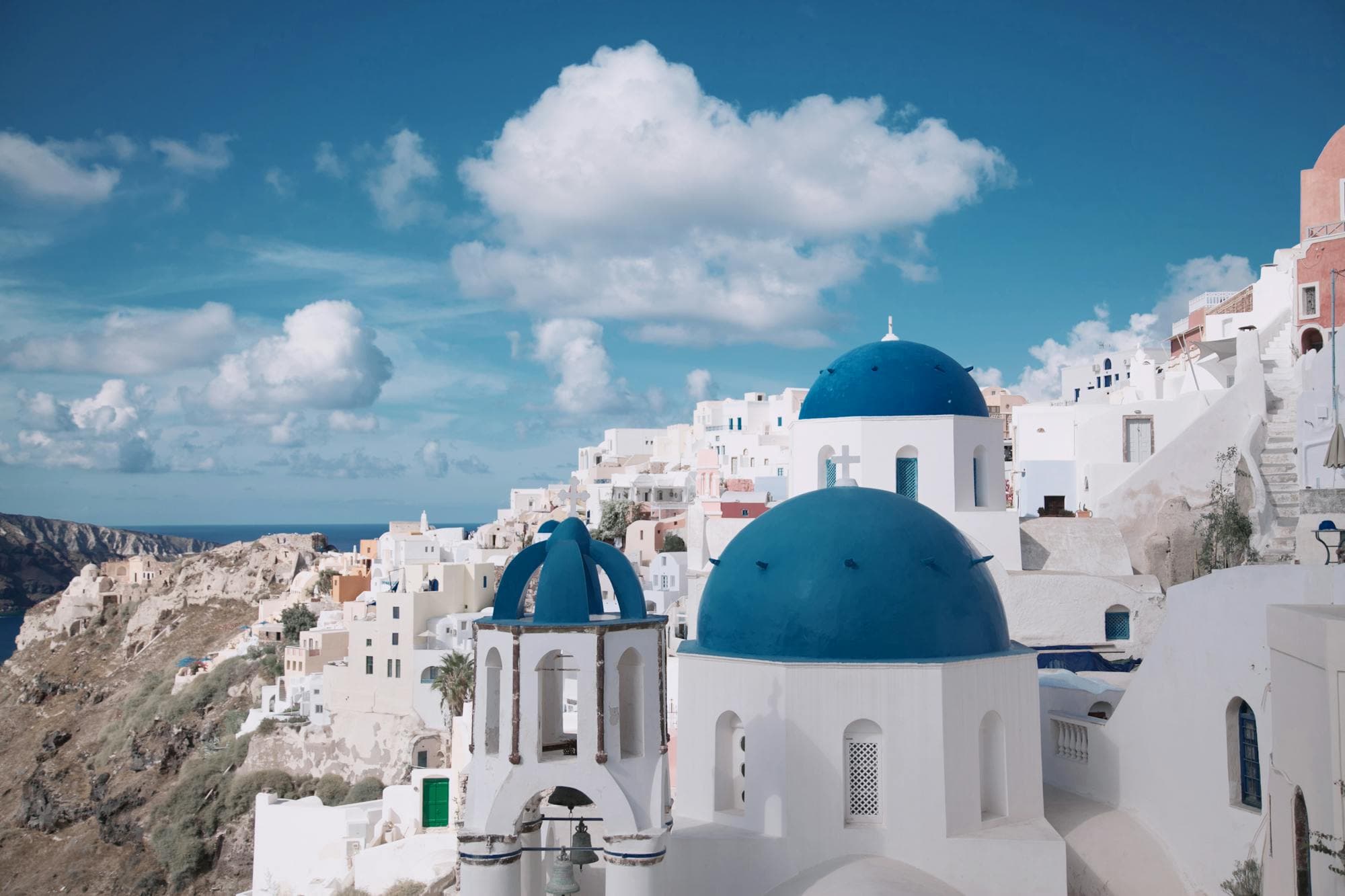 Iconic blue-domed churches and whitewashed houses of Oia, Santorini, Greece