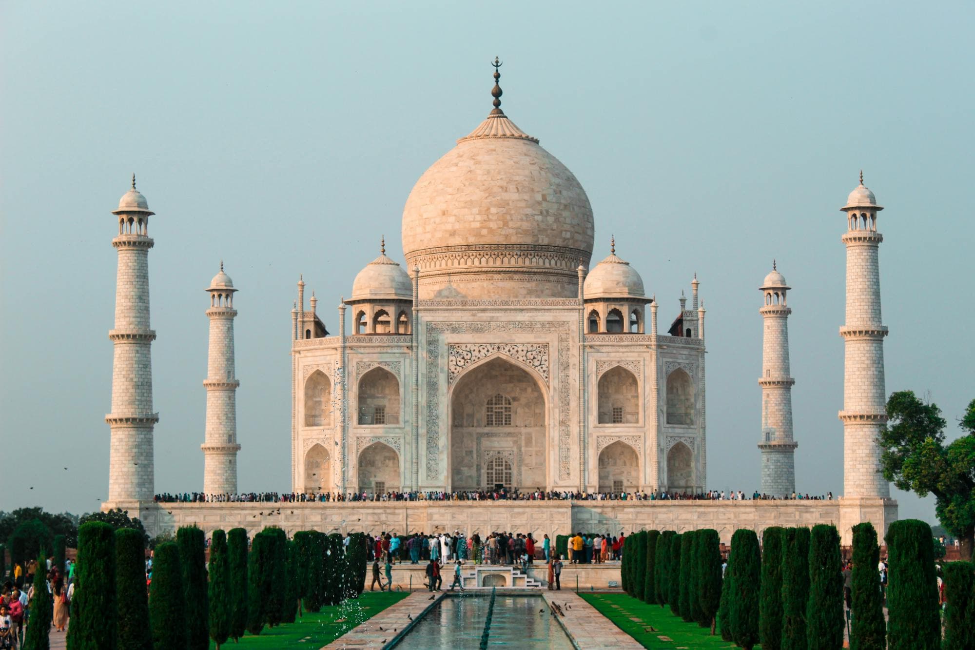 The Taj Mahal reflected in its long pool at sunrise, Agra, India