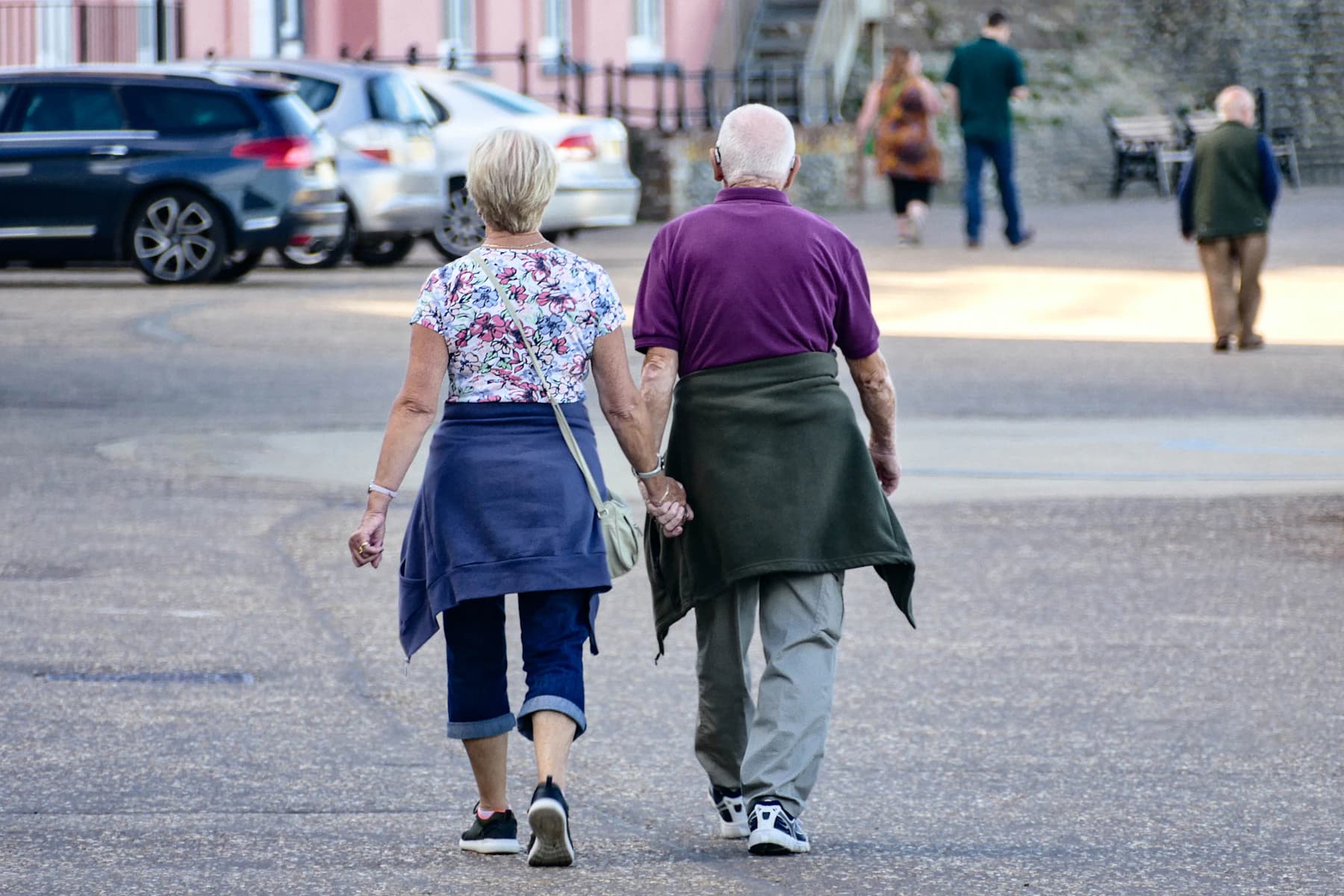 Older couple walking hand in hand on a city break
