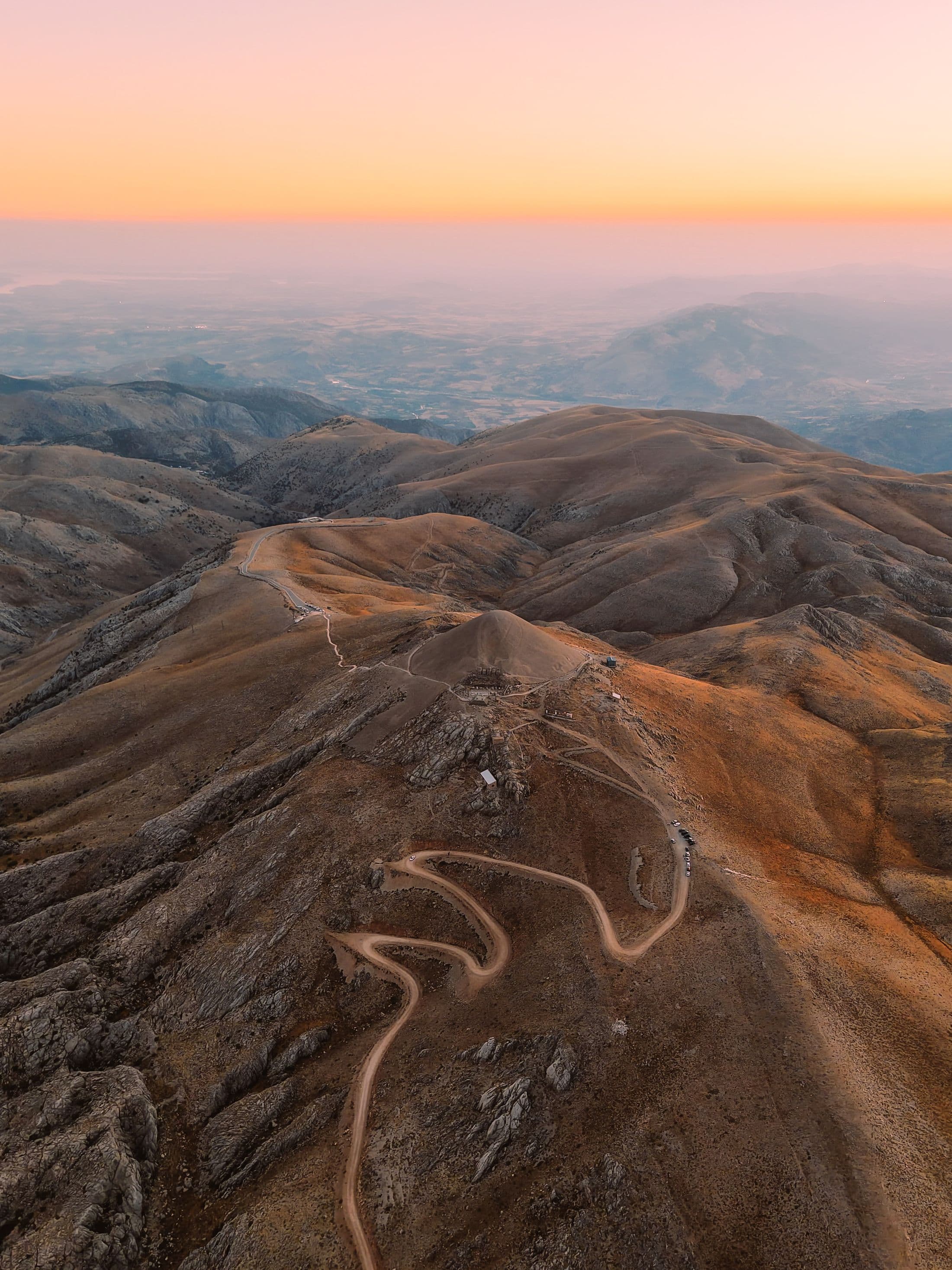 Aerial view of a winding mountain road at sunset