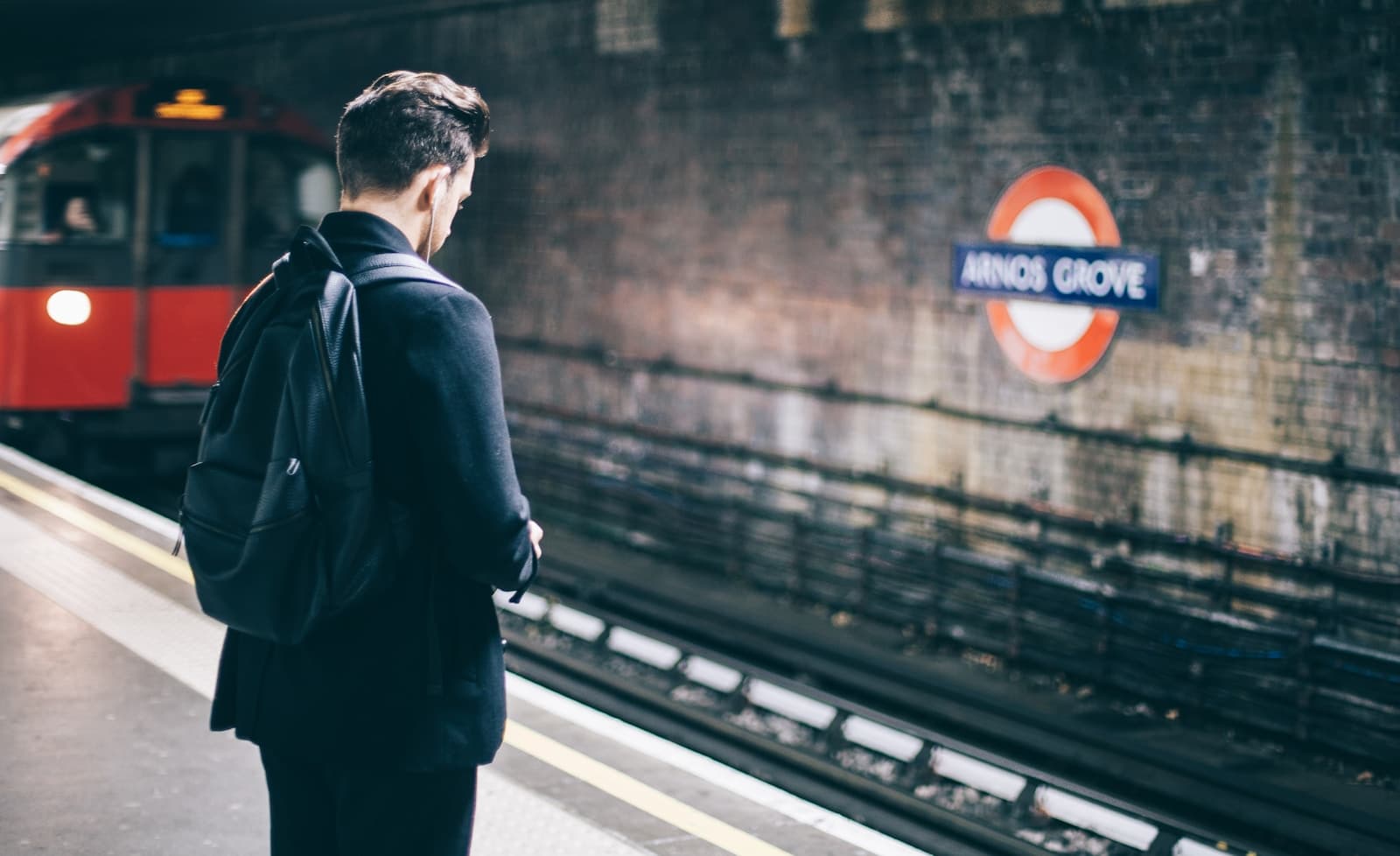 Young rail traveller waiting with a backpack on a European platform