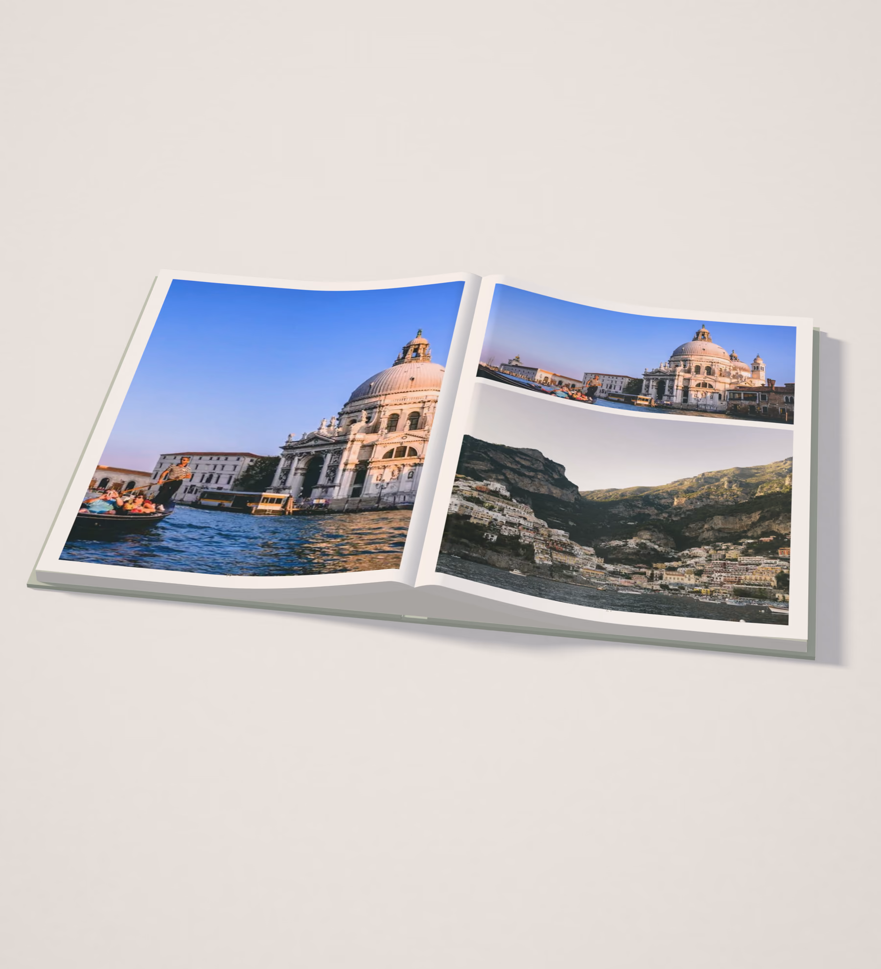 Hardcover travel photo book lying open on a pale studio table, with a Venice canal photo on the left page and Venice and Amalfi Coast photos on the right
