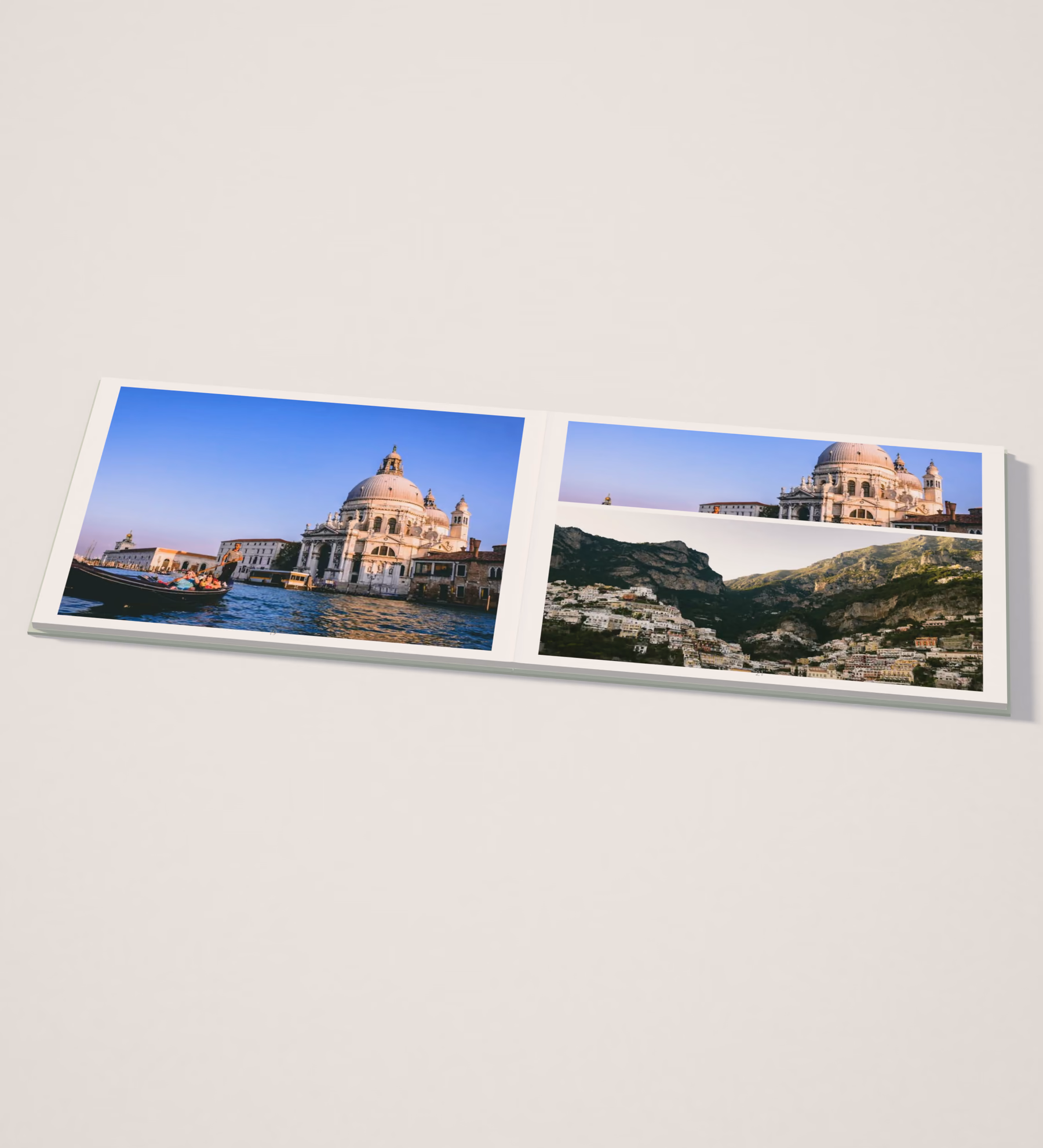 Layflat travel photo book lying open and completely flat on a pale studio table, with Venice and Amalfi Coast photos across both pages