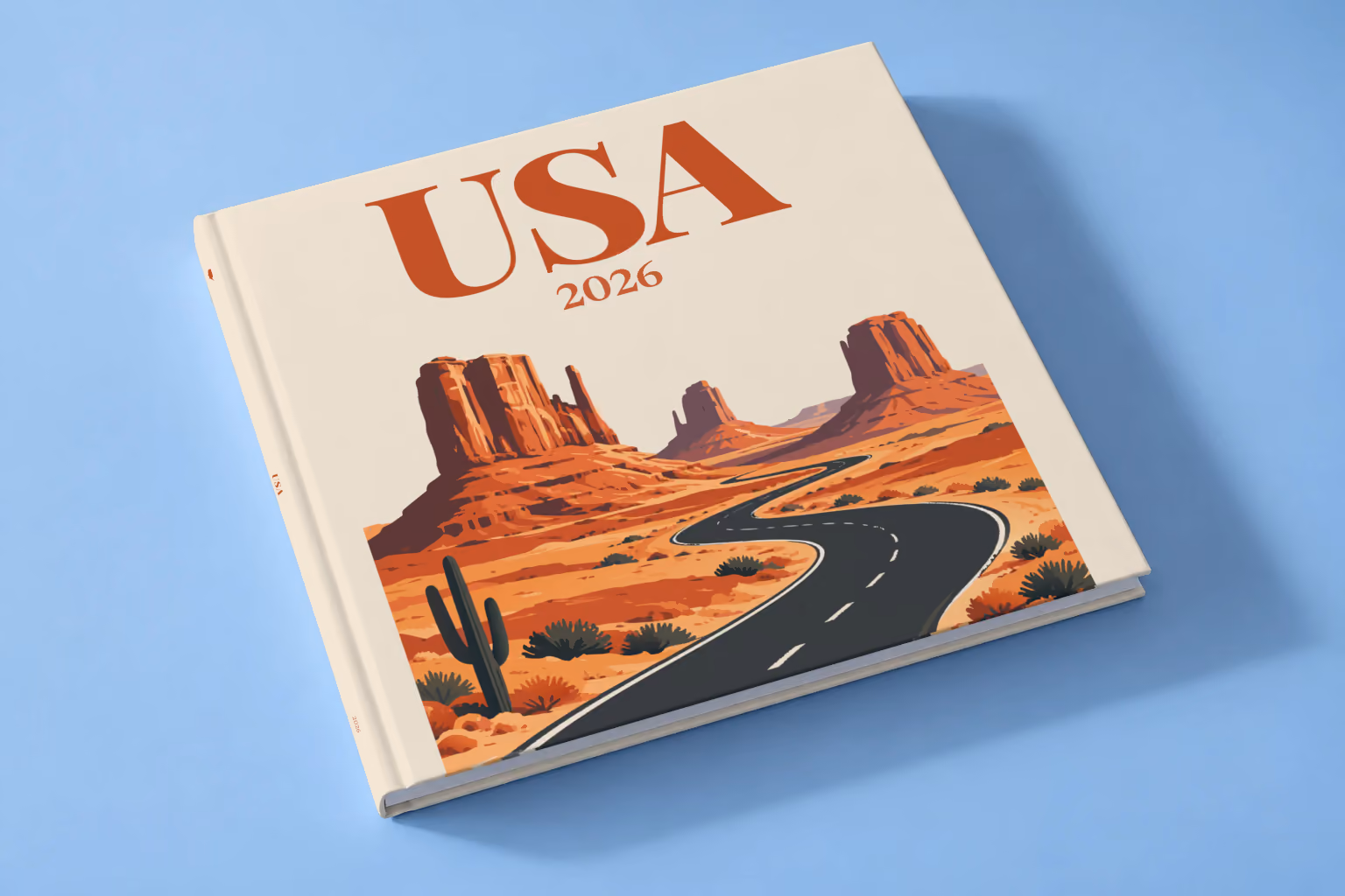 Arizona square hardcover photo book with the USA illustrated cover of the road through the red buttes of Monument Valley on sand, lying on a pale blue studio backdrop