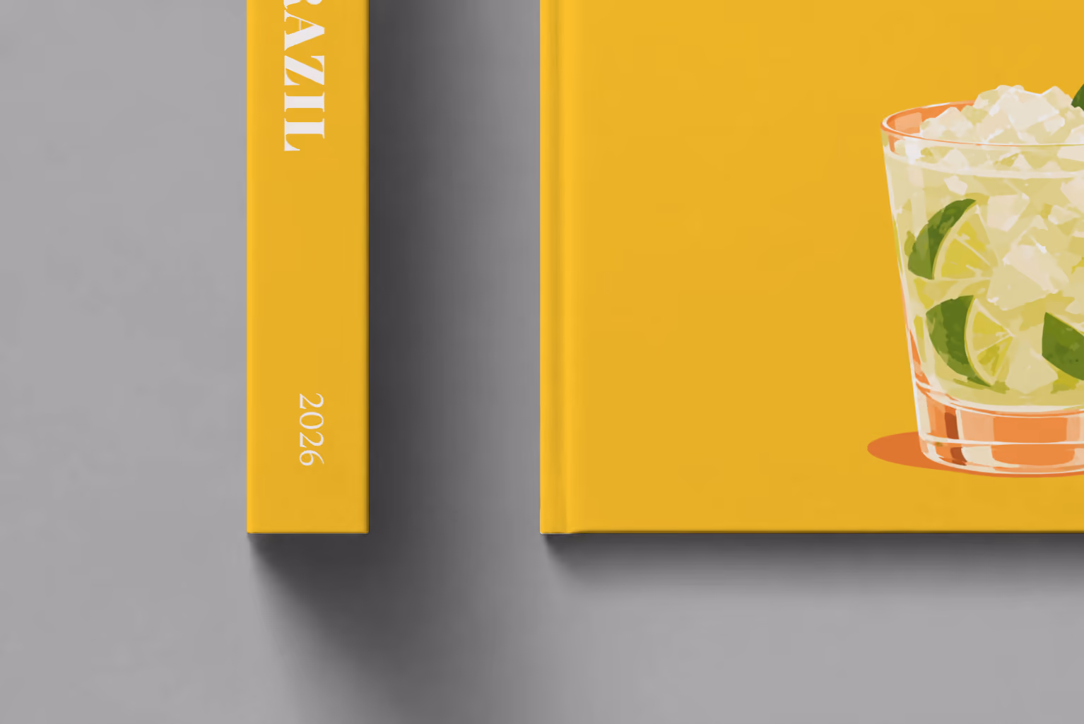 Brazil hardcover photo book with the illustrated cover of a caipirinha with crushed ice and lime on golden yellow, shown close up beside its spine on a pale grey studio surface