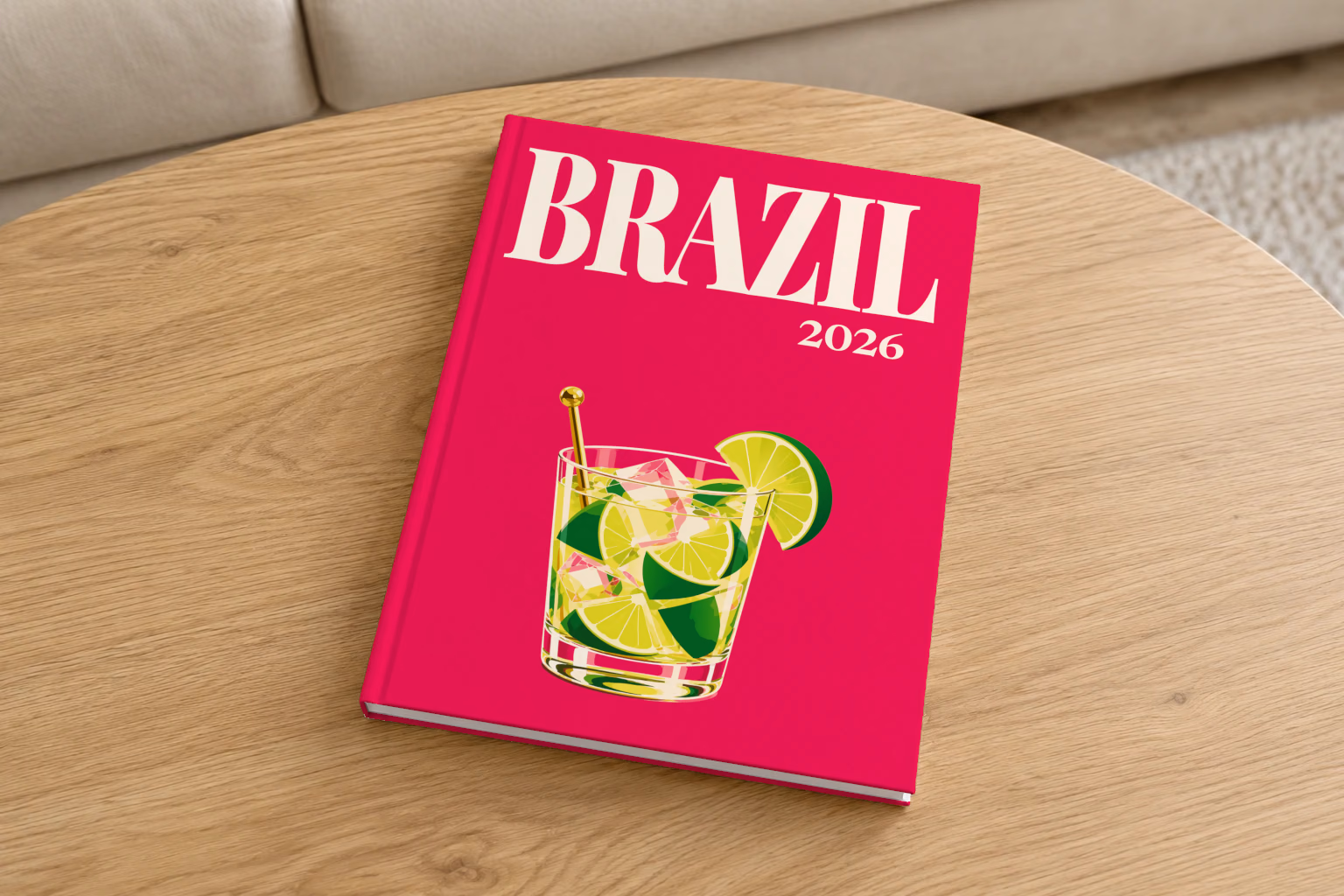 Brazil hardcover photo book with the illustrated cover of a caipirinha with lime wedges on magenta, on a round oak coffee table in a bright living room