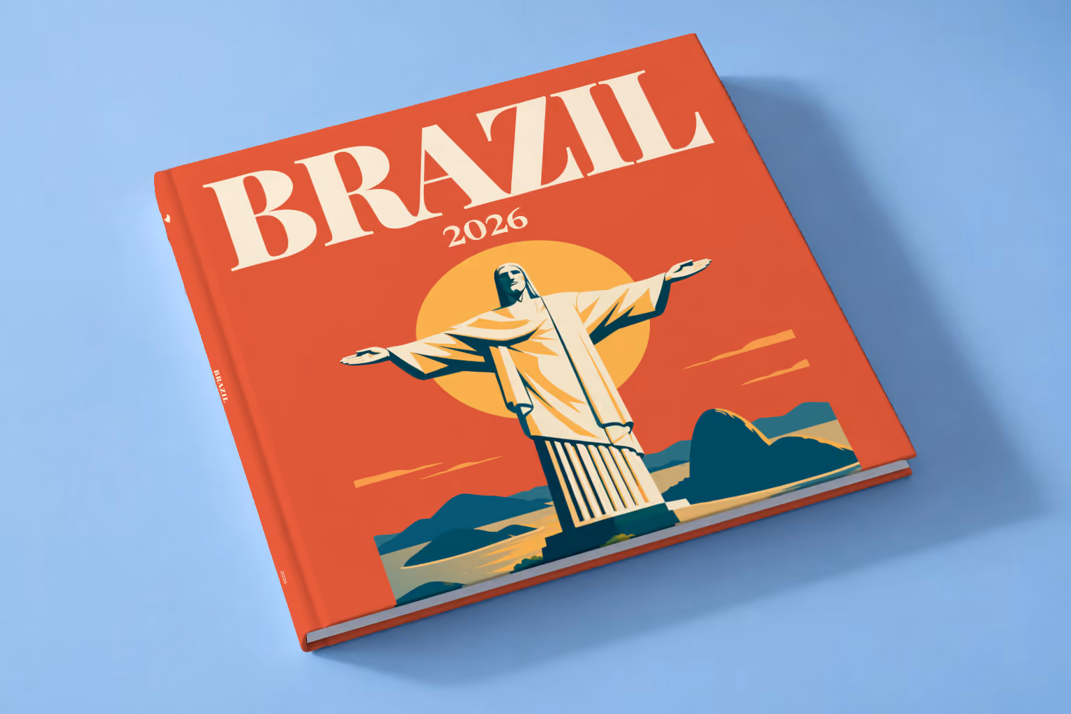 Brazil square hardcover photo book with the illustrated cover of Christ the Redeemer above Rio de Janeiro's bay at sunset on red-orange, lying on a pale blue studio backdrop