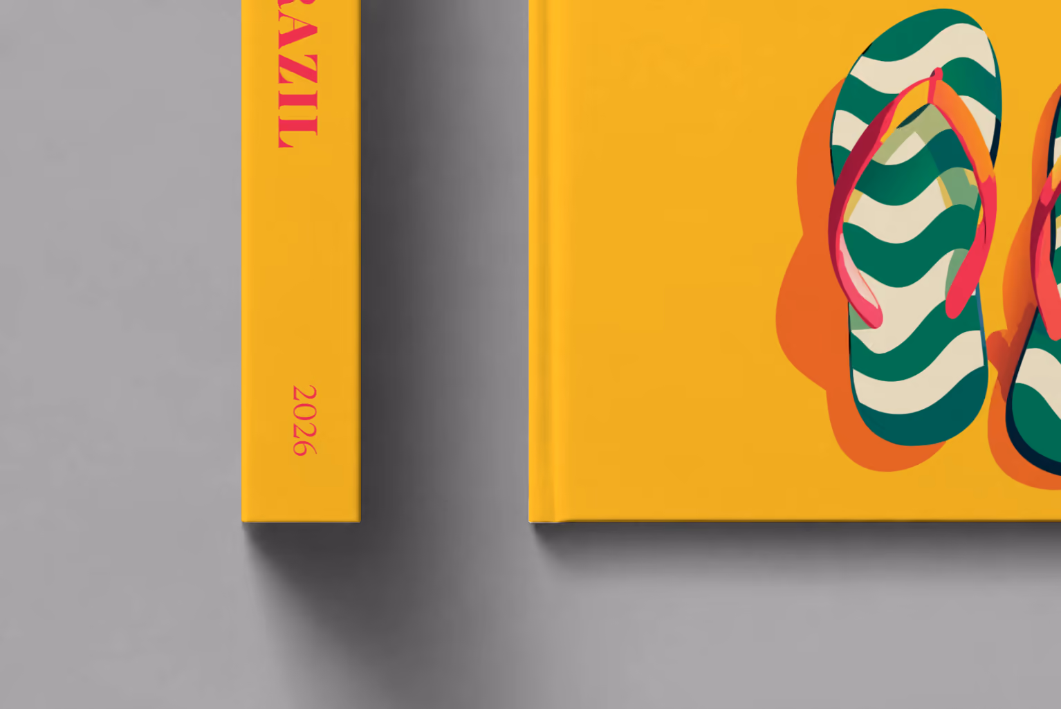 Brazil hardcover photo book with the illustrated cover of a pair of flip-flops in Copacabana's wave pattern on yellow, shown close up beside its spine on a pale grey studio surface