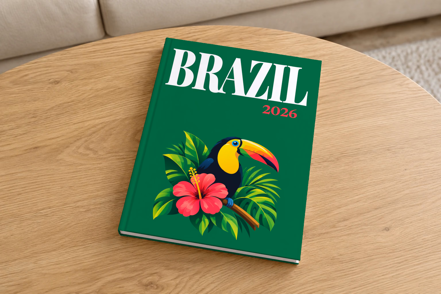 Brazil hardcover photo book with the illustrated cover of a toucan among tropical leaves and a pink hibiscus on emerald green, on a round oak coffee table in a bright living room