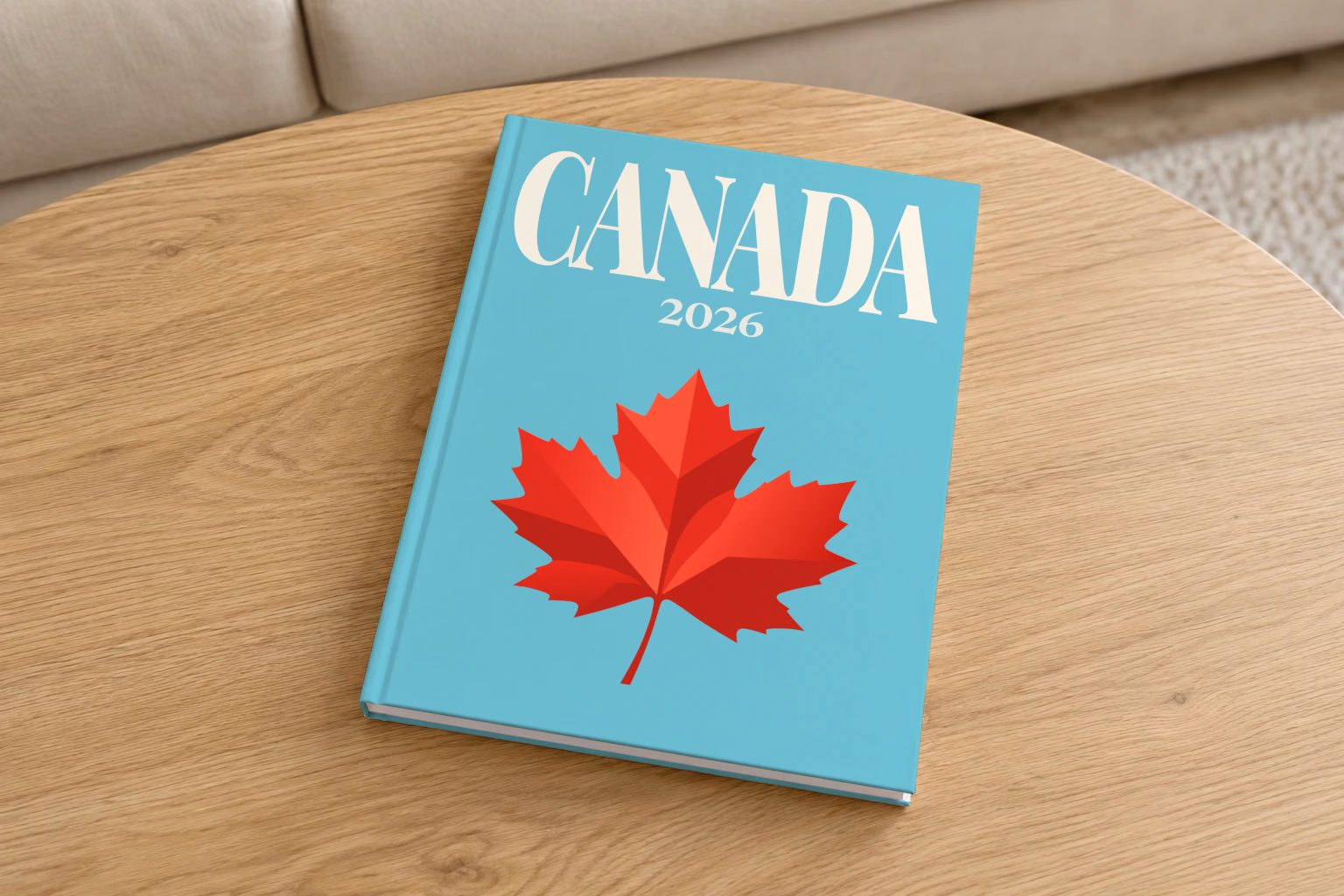 Canada hardcover photo book with the illustrated cover of a red maple leaf on turquoise, on a round oak coffee table in a bright living room