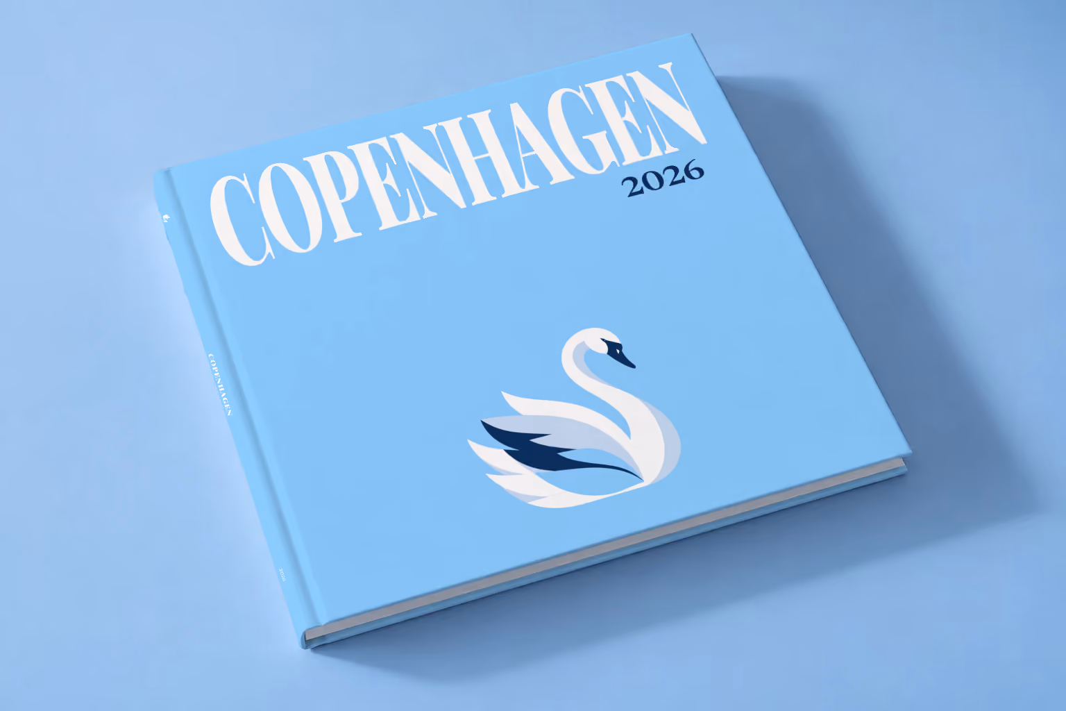 Denmark square hardcover photo book with the Copenhagen illustrated cover of a white swan on sky blue, lying on a pale blue studio backdrop