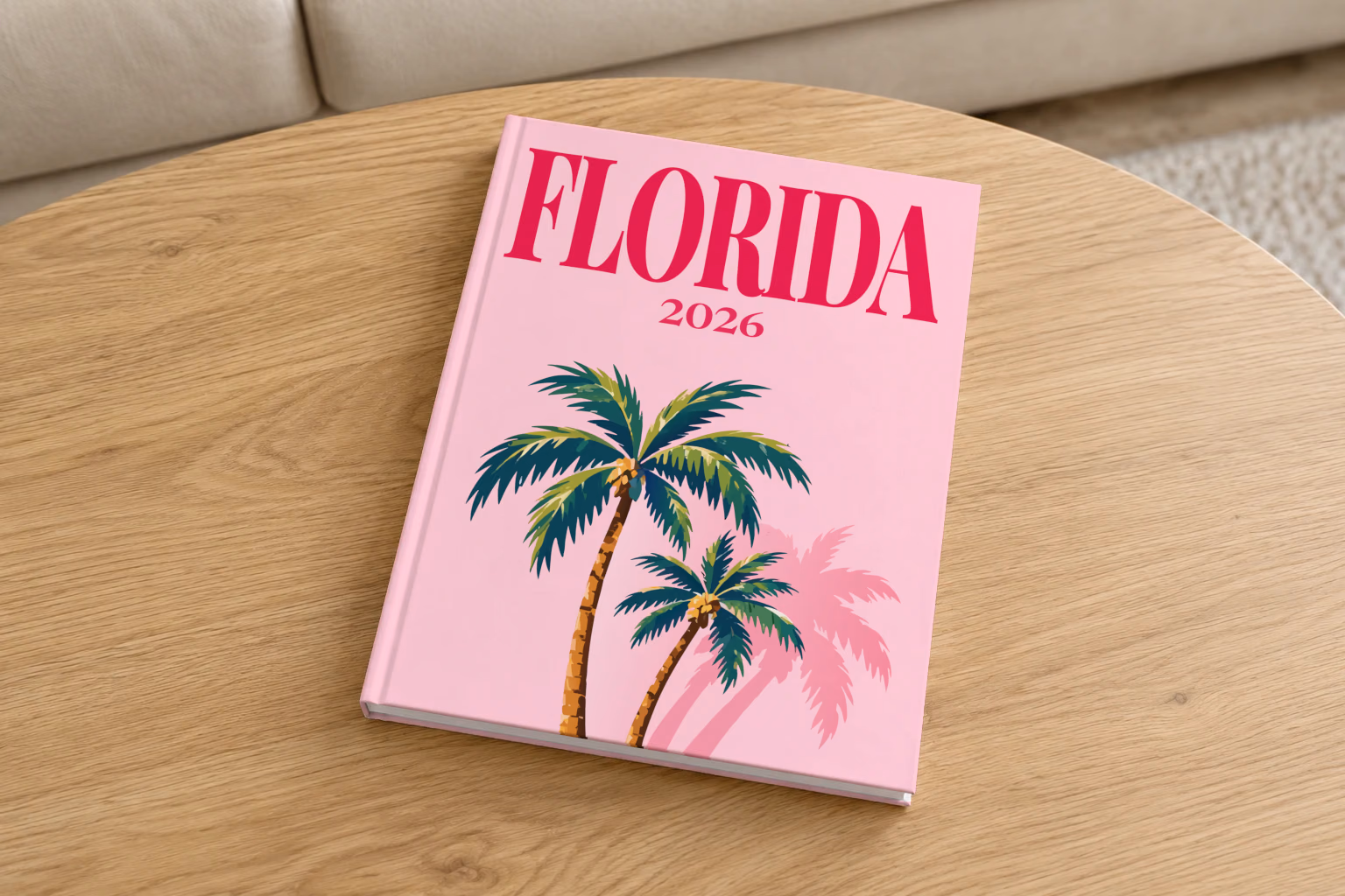 Florida hardcover photo book with the illustrated cover of Florida palm trees on pink, on a round oak coffee table in a bright living room