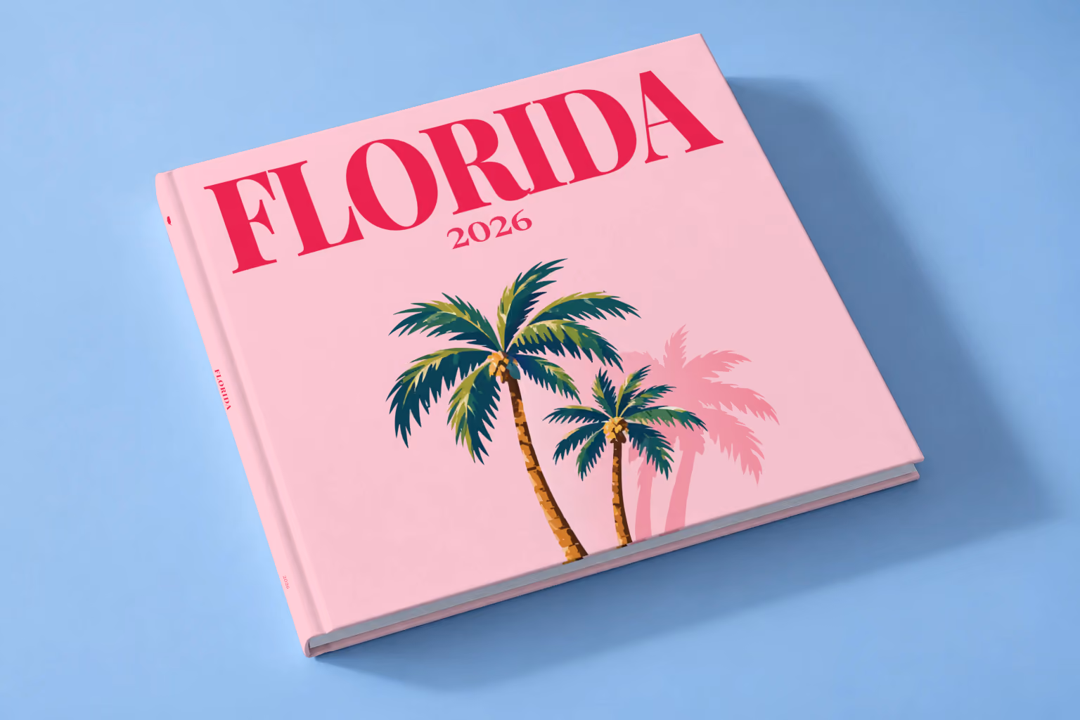Florida square hardcover photo book with the illustrated cover of Florida palm trees on pink, lying on a pale blue studio backdrop