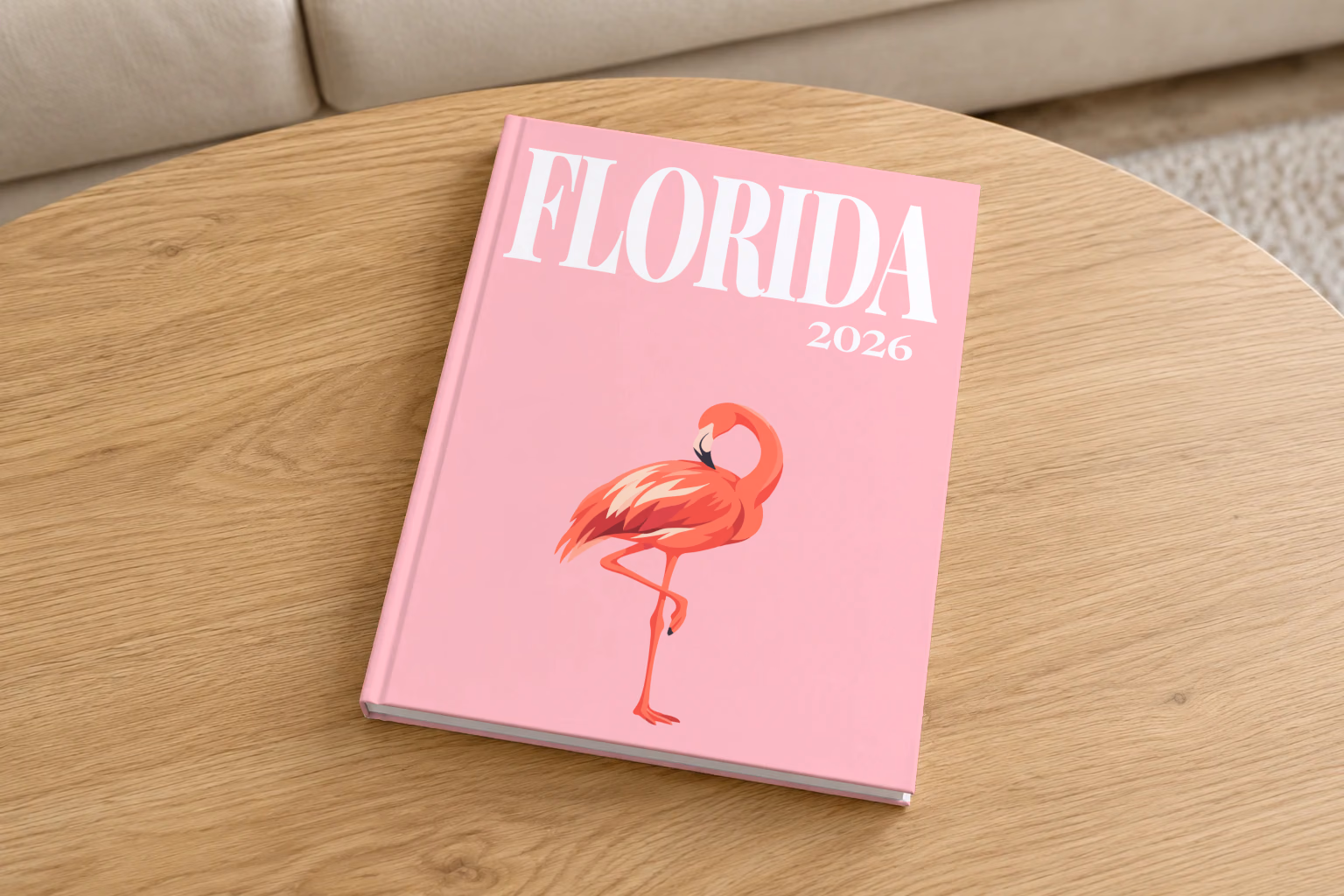 Florida hardcover photo book with the illustrated cover of a pink flamingo on pink, on a round oak coffee table in a bright living room