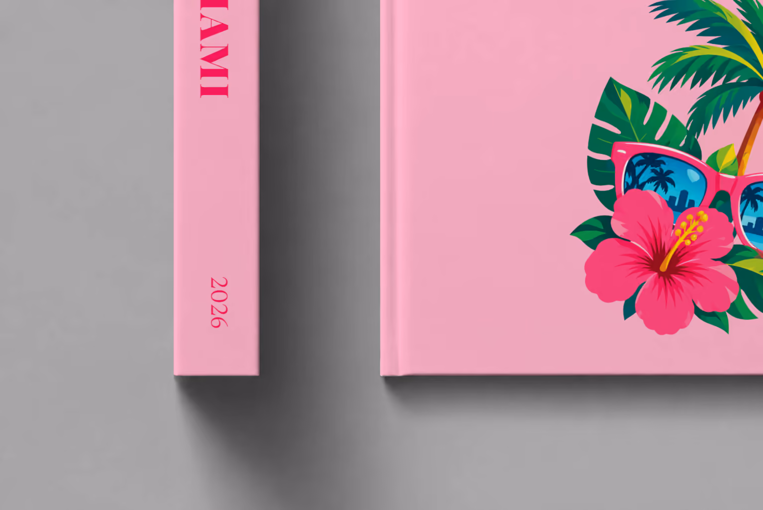 Florida hardcover photo book with the Miami illustrated cover of pink sunglasses reflecting palm trees, with hibiscus, on pink, shown close up beside its spine on a pale grey studio surface