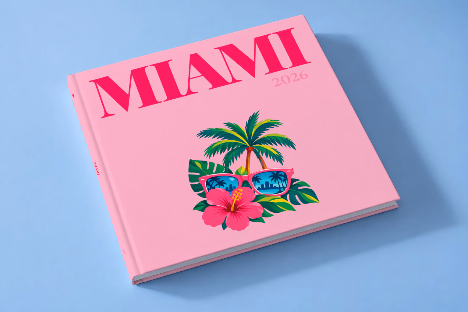 Florida square hardcover photo book with the Miami illustrated cover of pink sunglasses reflecting palm trees, with hibiscus, on pink, lying on a pale blue studio backdrop