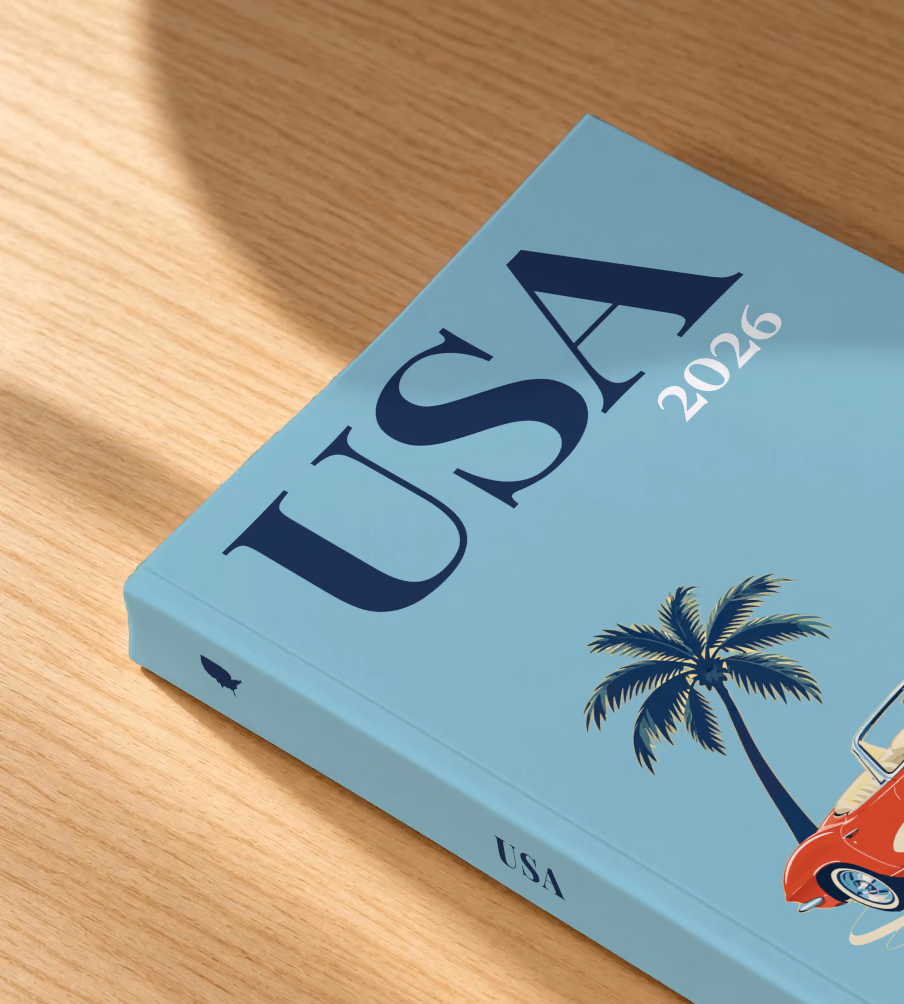 Florida softcover photo book with the USA illustrated cover of a red Corvette and a palm tree on dusty blue, lying on an oak desk in dappled afternoon sunlight