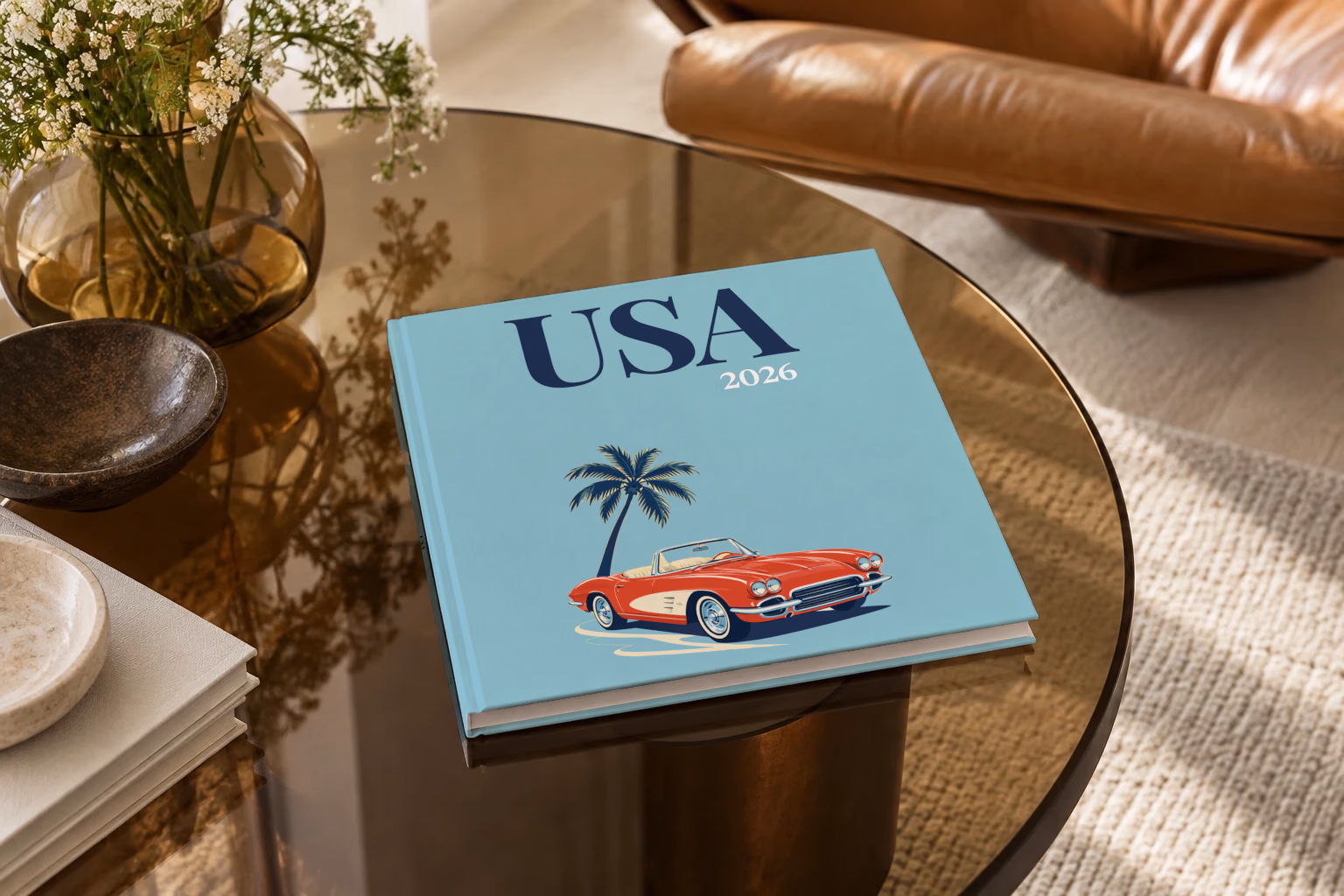 Florida square hardcover photo book with the USA illustrated cover of a red Corvette and a palm tree on dusty blue, on a smoked glass coffee table beside a leather armchair in warm afternoon light