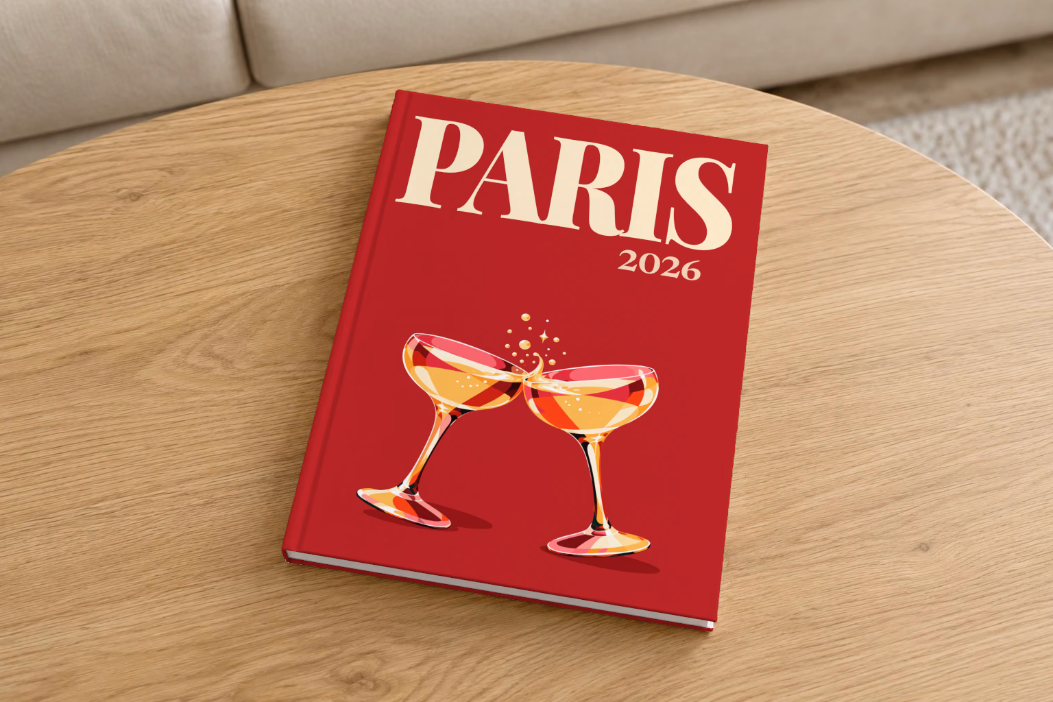 France hardcover photo book with the Paris illustrated cover of two champagne coupes on deep red, on a round oak coffee table in a bright living room