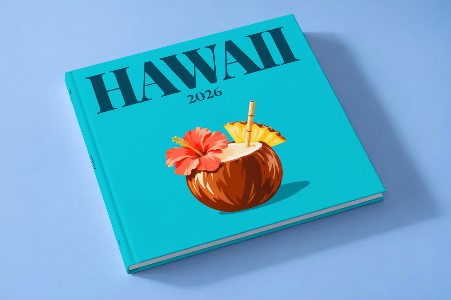 Hawaii square hardcover photo book with the illustrated cover of a coconut drink with hibiscus and pineapple on turquoise, lying on a pale blue studio backdrop