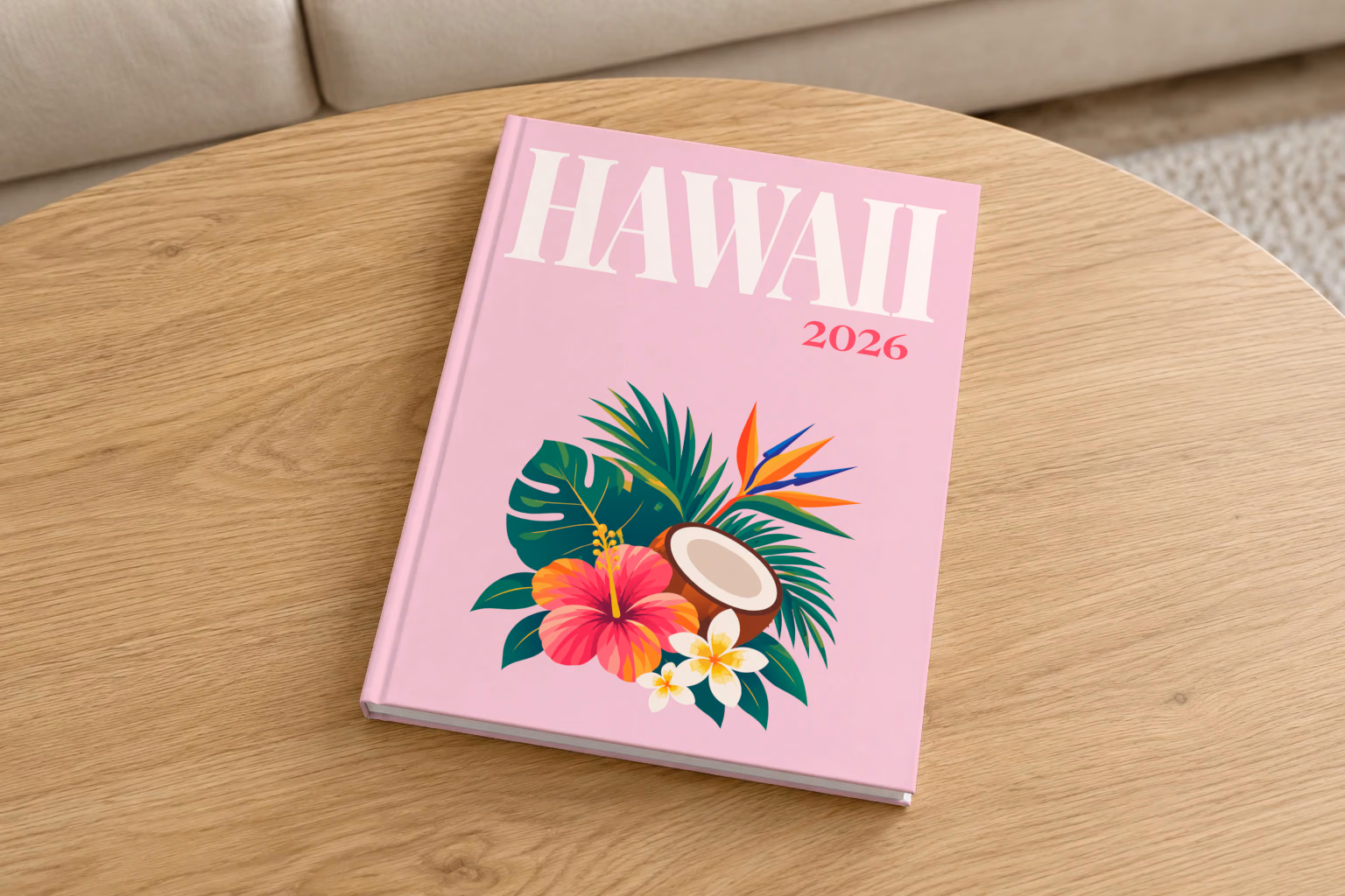 Hawaii hardcover photo book with the illustrated cover of a tropical bouquet with hibiscus, a coconut and palm leaves on pale pink, on a round oak coffee table in a bright living room