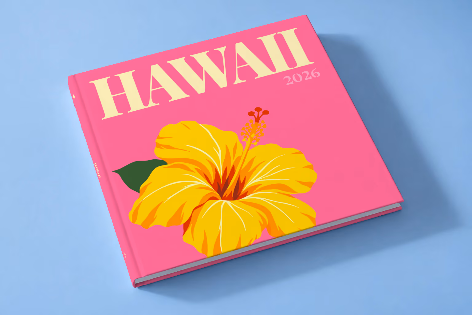 Hawaii square hardcover photo book with the illustrated cover of a yellow hibiscus on pink, lying on a pale blue studio backdrop