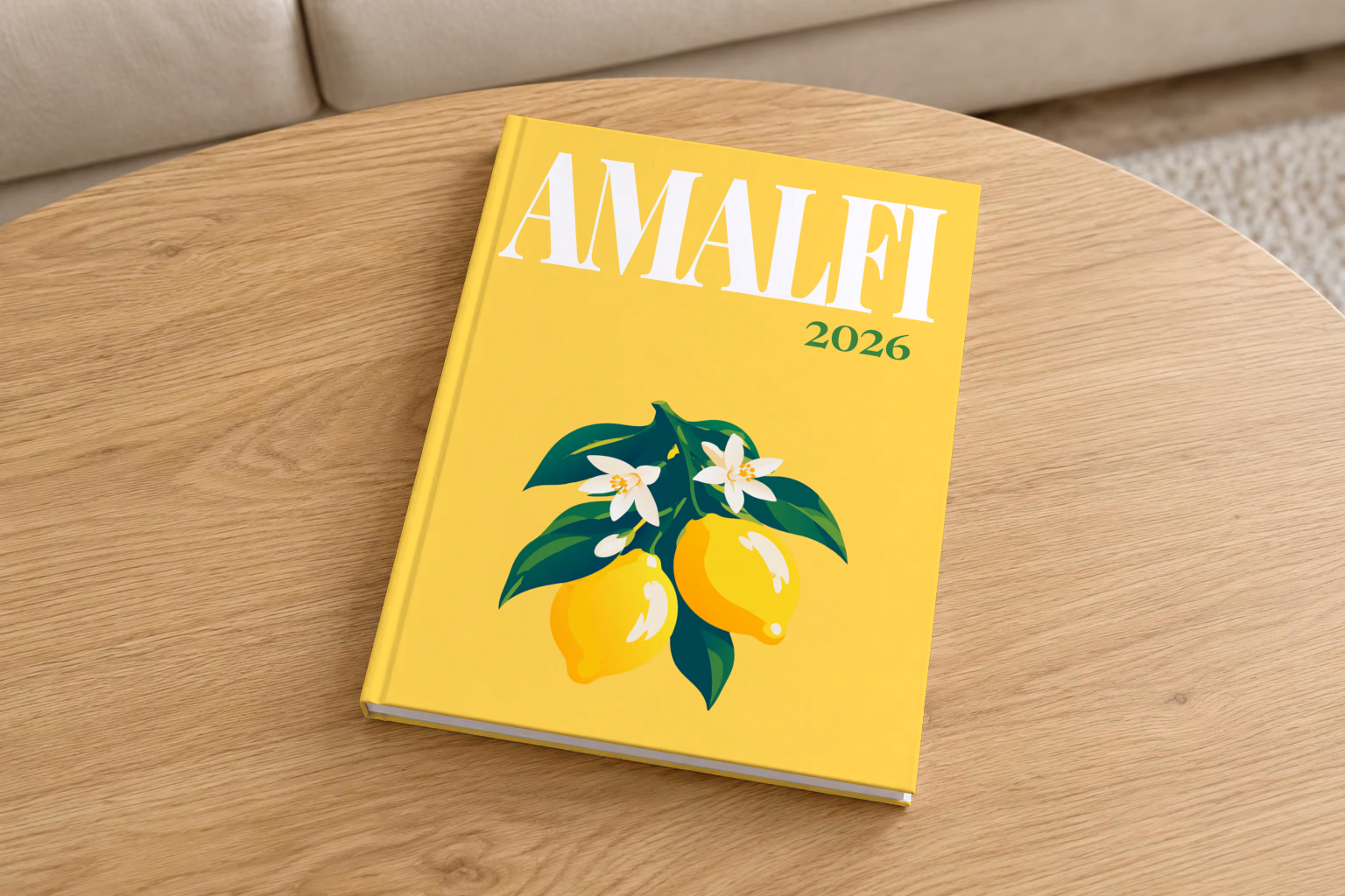 Italy hardcover photo book with the Amalfi illustrated cover of lemons and blossom on yellow, on a round oak coffee table in a bright living room