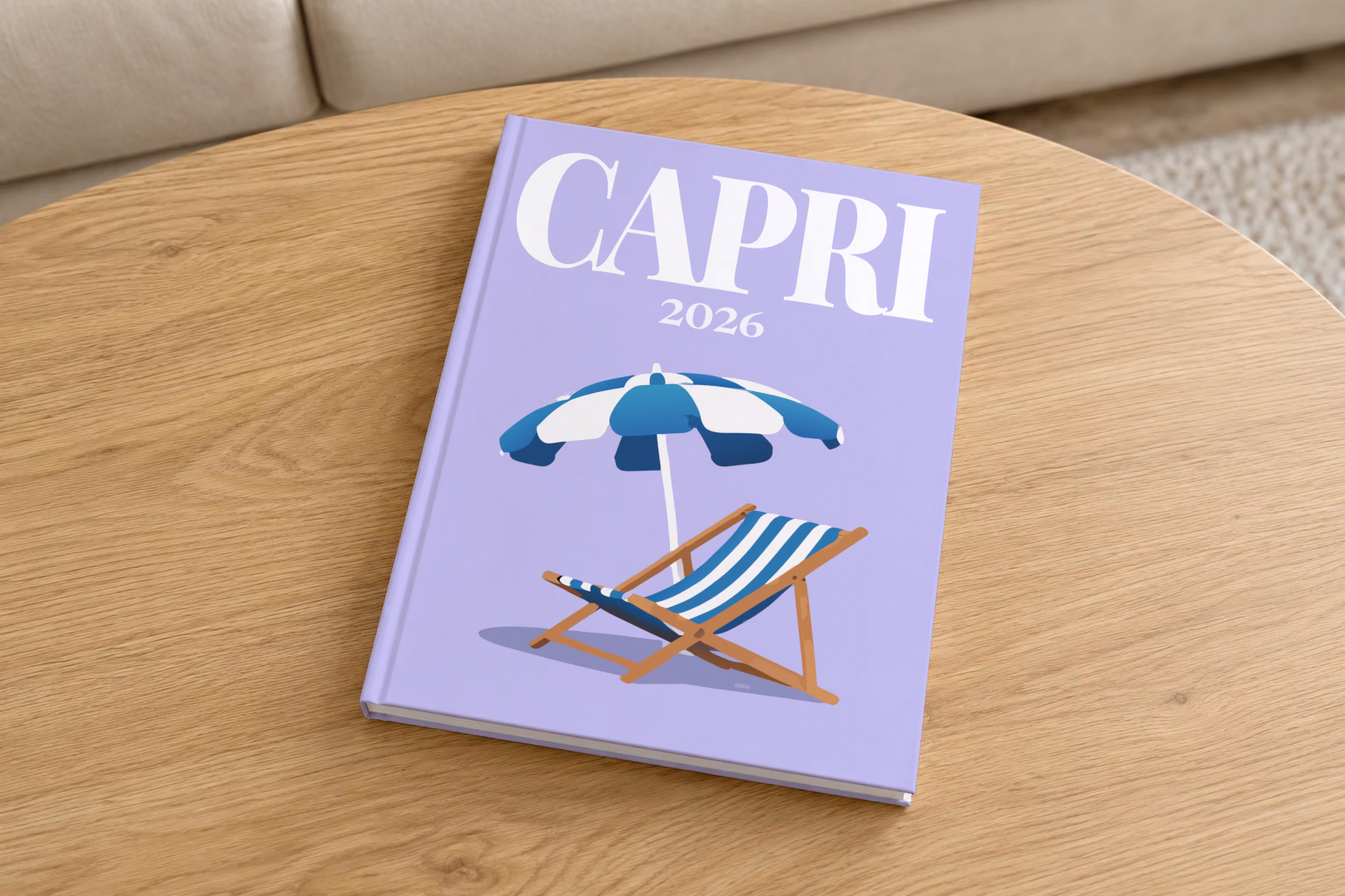 Italy hardcover photo book with the Capri illustrated cover of a striped beach umbrella and deckchair on lilac, on a round oak coffee table in a bright living room