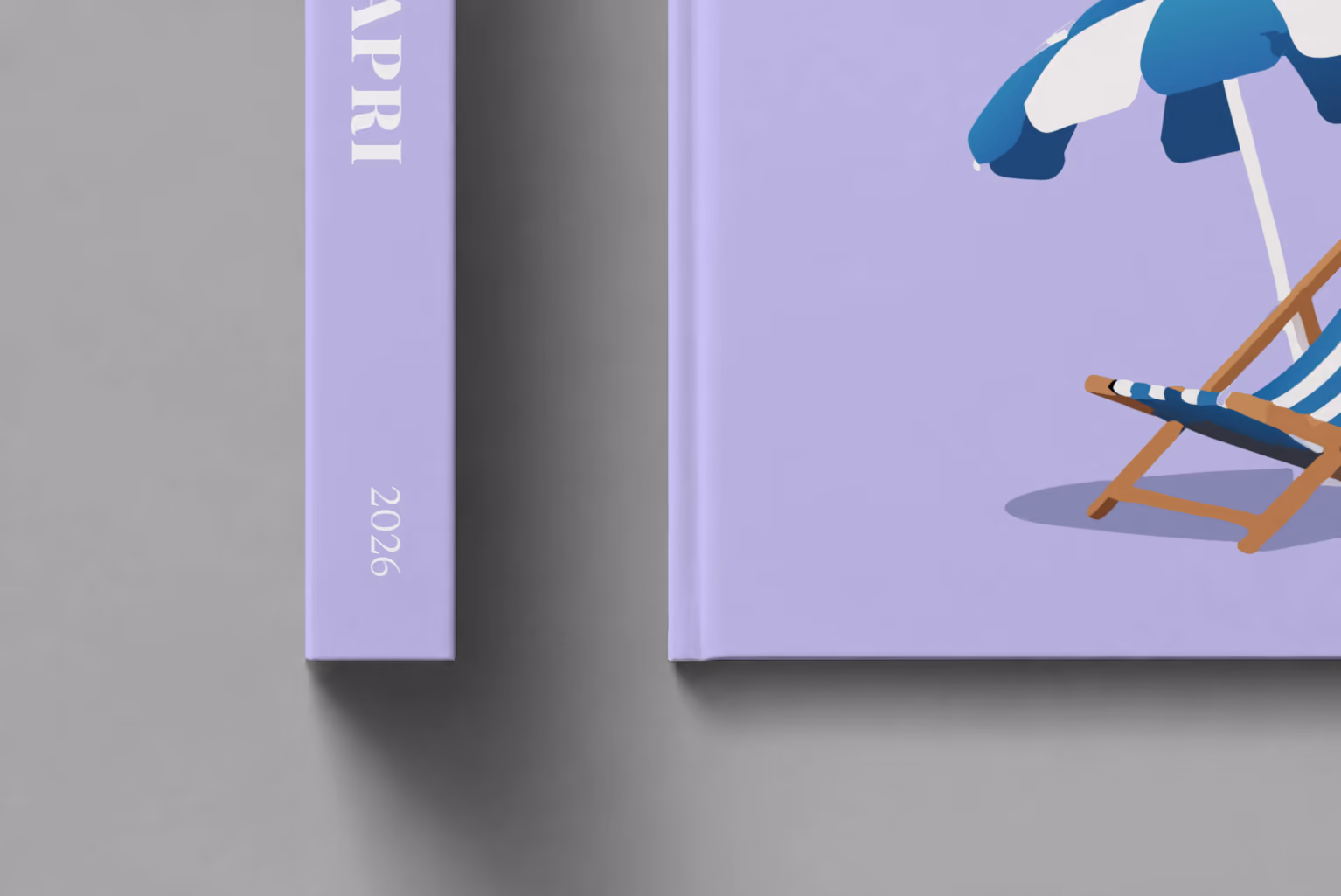 Italy hardcover photo book with the Capri illustrated cover of a striped beach umbrella and deckchair on lilac, shown close up beside its spine on a pale grey studio surface