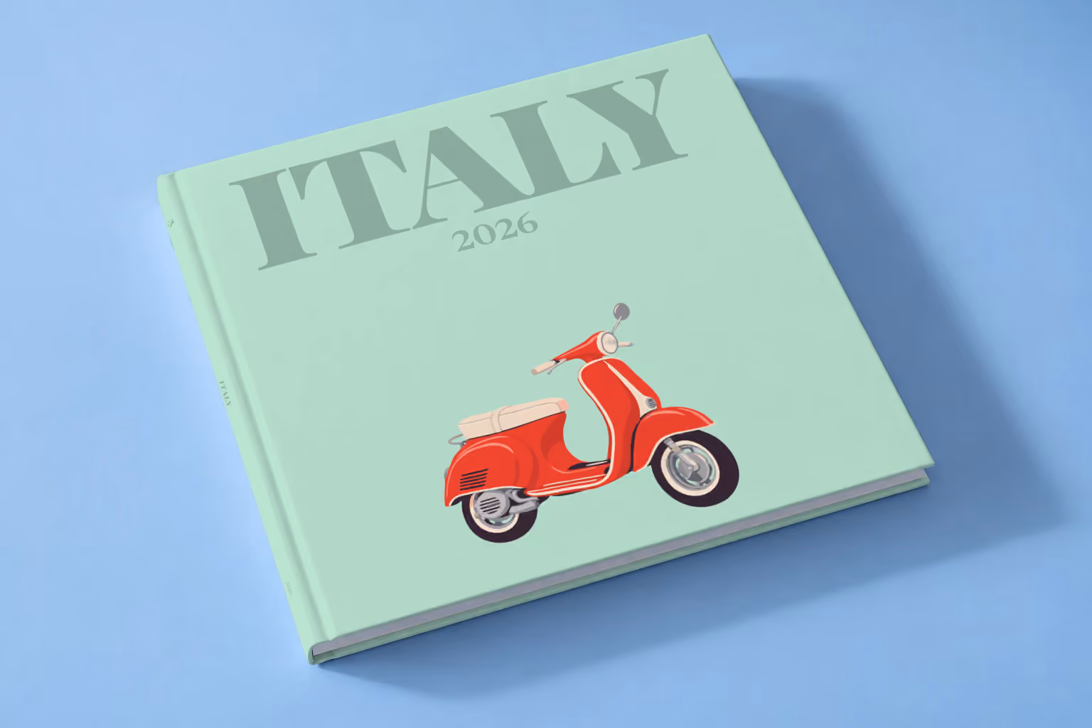 Italy square hardcover photo book with the illustrated cover of a red Vespa scooter on mint green, lying on a pale blue studio backdrop