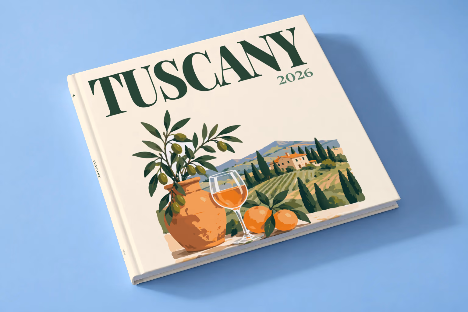 Italy square hardcover photo book with the Tuscany illustrated cover of an olive tree, a glass of wine and Tuscan vineyards on cream, lying on a pale blue studio backdrop