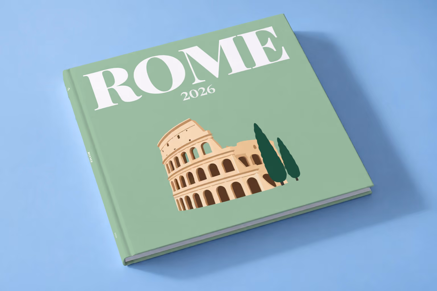 Italy square hardcover photo book with the Rome illustrated cover of the Colosseum and cypress trees on sage green, lying on a pale blue studio backdrop