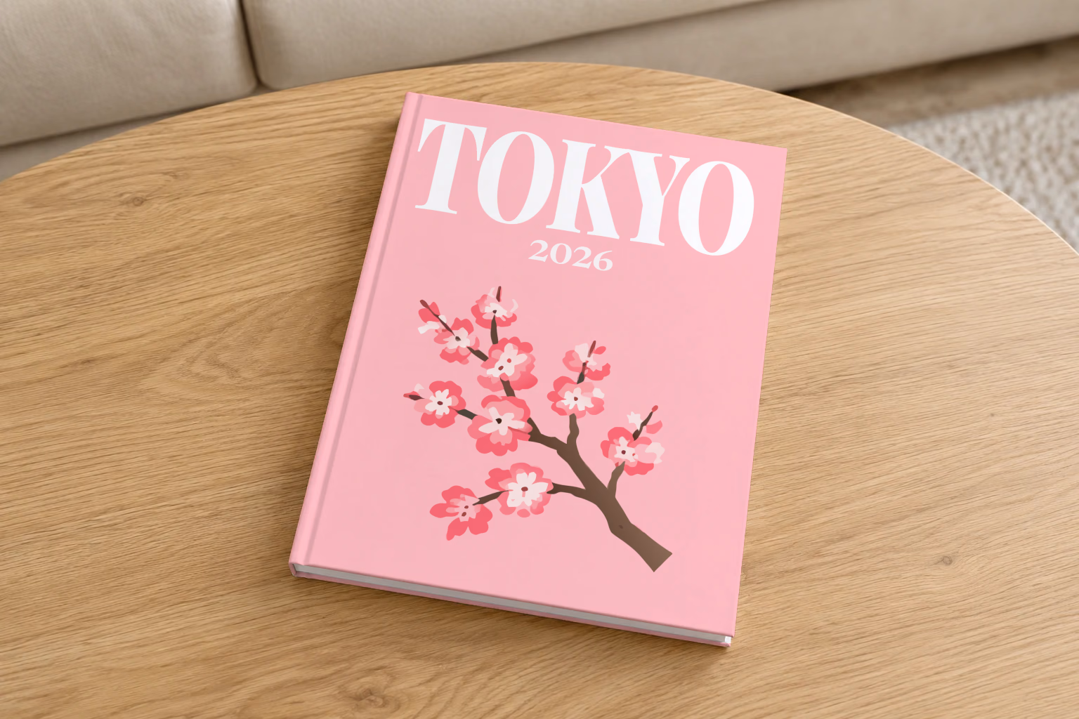 Japan hardcover photo book with the Tokyo illustrated cover of a cherry blossom branch on pink, on a round oak coffee table in a bright living room