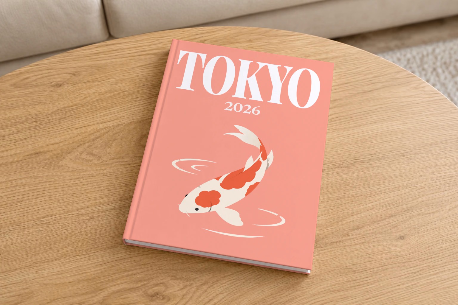 Japan hardcover photo book with the Tokyo illustrated cover of a koi on coral pink, on a round oak coffee table in a bright living room